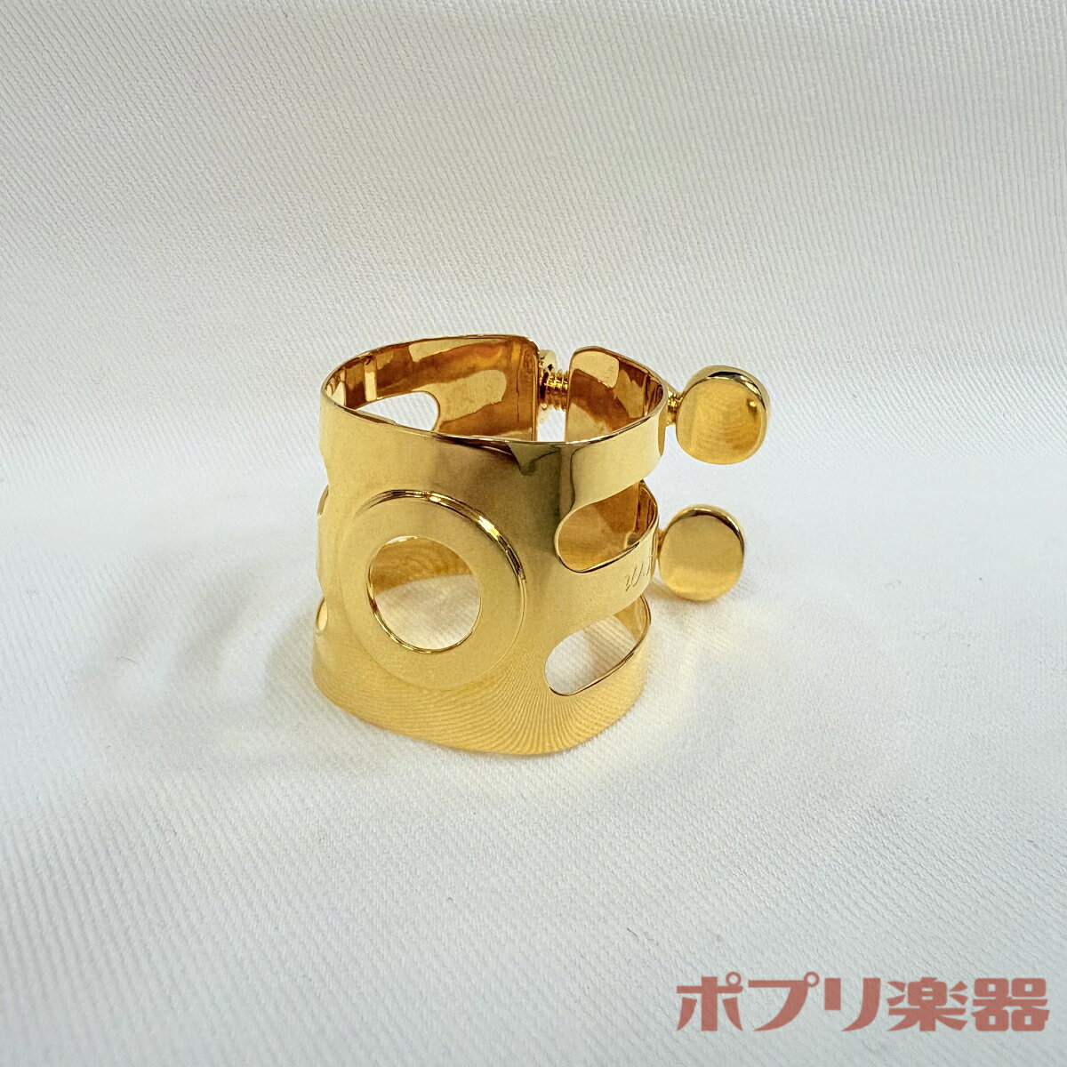 素材に真鍮を使用したオリジナルリガチャー。 ボリュームの大きさとレスポンスの速さを併せ持ち、 重厚ながらも柔らかく伸びのある音色が得られます。 2本のレールでリードを固定し、リードからリガチャーを離すことによってリード本来の振動を活かします。 また、中央にリングを設けることで強度を上げています。 長くご使用いただくためにネジ1本1本にもこだわりを持ち、鋳物ではなく削り出しで製作しています。 仕様 形状 逆締め 素材 真鍮 仕上げ 金メッキ ・沖縄・離島などの一部地域への配送は、通常よりお時間が掛かる場合がございます。