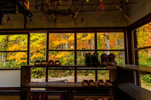 【日本の風景／地名のポストカード】群馬県尾瀬 山小屋の窓辺に並ぶ登山靴と鮮やかな紅葉　はがき お土産 ハガキ　撮影/daikegoro