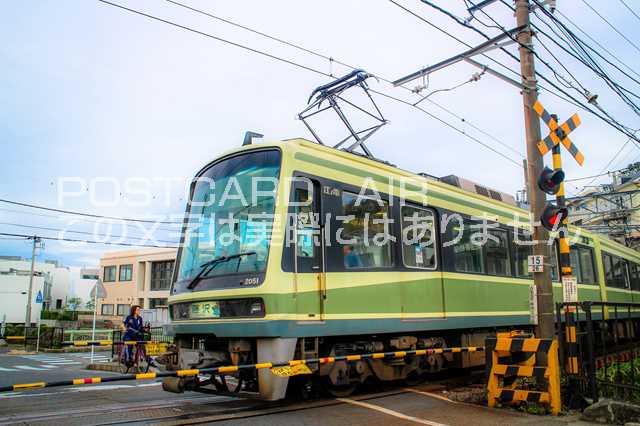 【鉄道のポストカード】踏切を通過する黄緑色の江ノ電2051号車、自転車の女性とすれ違う一コマ はがき お土産 ハガキ 撮影/MIRO