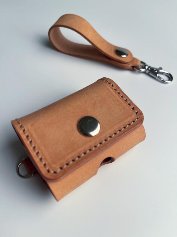 Spring Hiker Airpods Pro カバー - プレミアムイタリアンレザー製 全面保護 本革カバー | 第1 / 2世代対応 (Naturale, シルバー)プレミアム素材: 高品質のイタリアンレザーを使用した当製品は、手触りが良く耐久性に優れています。自然なタン色を含め、さまざまな色彩のバリエーションを徐々に展開していく予定です。専用設計: Airpods Pro 第1 / 2世代にぴったり合うように設計されており、デバイスを全方向から守ります。充電ポートへのアクセスを可能にする切り欠きがあり、使い勝手を損ないません。AirPods Pro 第3世代（Pro3）は数値上収納可能ですが、本革の特性上、新品時は非常にタイトで蓋の開閉に支障が出る場合があるため、推奨しておりません。機能的ディテール: 使いやすさを考慮したスナップボタン、取り外し可能なレザーストラップには金属製クリップが付いており、バッグやベルトループに簡単に取り付けられます。全面保護: 厚みのあるレザーとしっかりとした作りで、落下時の衝撃を吸収し、日常のキズやほこりからAirpods Proを保護します。エレガントなスタイル: 手仕事による精細なステッチが特徴で、フォーマルからカジュアルまで、どんなスタイルにもマッチします。ギフトにも最適: 高級感あふれる外観と実用性を兼ね備えたこのケースは、大切な人へのプレゼントにもふさわしい一品です。