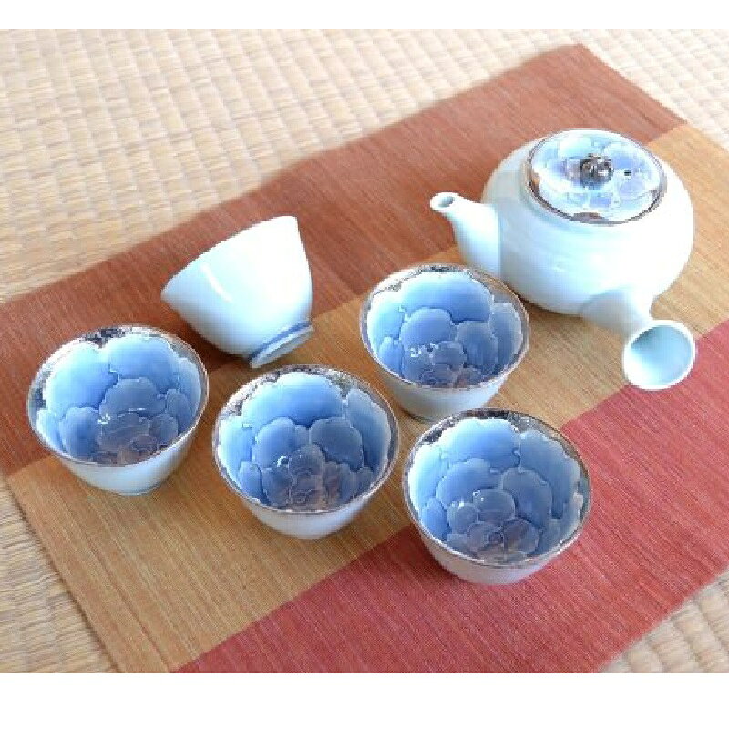 【サイズ】 （急須）胴径11.4cm×幅17.5cm×高さ7.8cm （煎茶）径7.9cm×高さ5.4cm 【容量】急須：410ml ◇材質：磁器 ◇生産地：日本（有田焼） 淡い青白磁の器の内側に、一珍技法で描かれた牡丹の花が艶やかに咲く茶器セットです。 花びらの縁にはプラチナが施され、光の加減で上品にきらめきます。 急須の蓋にも同様の牡丹文様があしらわれており、統一感のある美しさを演出。 急須1個と湯飲み5個がセットになっており、特別なおもてなしや贈り物にも最適です。 ステンレス製の茶漉し付きで、日常使いにも便利です。
