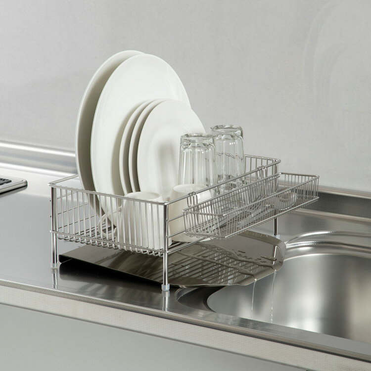 ■材質水切りかご:18-8ステンレス付属ゴム足:シリコーンゴムステンレスポケット:18-8ステンレス水切りトレー:18-8ステンレス■商品サイズ約358mm×322mm×142mm■商品重量約1,814g■原産国日本■セット内容ステンレス水切りかご(小)・ステンレスポケット(小)・ステンレス水切りトレー(小) 各1■商品説明毎日のお料理のモチベーションを高めるために大切なこと。その一つに、「使いやすく美しい道具を使う」ということがあります。使いやすさ、耐久性、お手入れのしやすさ、そして、美しさ。すべてがそろったラバーゼの水切り。使う人のために考え抜き、必然的に生まれたカタチ。la base(ラバーゼ)とはイタリア語で、基本、という意味。ラバーゼは『メイドインジャパン、上質、基本の料理道具』がコンセプトのキッチンウェアブランドです。著名な料理研究家・有元葉子さんと、世界に誇るステンレス製造技術を持つ『新潟県燕市』の職人たちと歩みを重ね、長い時間をかけて、ひとつひとつ、完成させました。使いやすさから生まれたシンプルなラインラバーゼの水切りの特徴ともいえるこの「ワイヤーがまっすぐ通っているだけのシンプルなデザイン」。一般的な水切りにある縦横に交差する補強ワイヤーがありません。これは、使いやすさにこだわった結果、たどり着いたカタチなのです。水切りかご(小)のワイヤーの向きを変更しました。これにより水切りかご(大)と同じようにディナー皿など大皿の水切りもできるようになり、使い勝手がさらによくなりました。いつも清潔に、スッキリと水切りは使用しているうちに、自然と水垢などの汚れがたまりやすいものです。特にワイヤータイプの水切りは、底の溶接部分(ワイヤーが交差している部分)に汚れが残りがち。お手入れもなかなか大変です。食器を入れる水切りかごは、いつも清潔であってほしい。ラバーゼの水切りは、汚れがたまらず清潔に保てるよう、ワイヤーの溶接部分を無くしました。水キレもよく、お手入れもサッと拭くだけでカンタンです。お皿が凛と立つ食器の乾かしやすさ、収納性、安定性、すべてに配慮するために、ワイヤーの間隔を細かくしました。ワイヤーの間隔が細かいので、大皿も小皿もしっかりとはまり、凛と立ちます。大量のお皿も迷うことなくサクサク入れることができ、水キレもよい。省スペースになるので収納性もグッとアップします。大切なアイテムをしっかり守るまた、ワイヤーの間隔が細かいことで、底がフラットになります。大切なワイングラスや繊細なグラスを置いてもグラつかず、やさしく受け止めてくれます。ワイヤーの隙間から落としてしまいがちな小物アイテムにもうれしい配慮です。水気の多いシンク周りでもしっかり安定するよう、足には専用の透明カバーを付けました。食器をたくさん入れてもグラつかないので、安心して洗い物をすることができます。また、4本足でスッキリしているので、水切りかご下のお掃除もしやすいです。料理がスムーズになる浅型食器の出し入れをしやすくするために、かごを浅めに設計しました。お料理しながら洗い物をしたり。洗ったものを、またすぐ使ったり、水切りの出番は意外と多いものです。置きやすくて、取り出しやすいと、お料理が驚くほどスムーズになります。水がたまらない形状とコーティングでいつも清潔ななめに傾いているので、洗い物の水がトレーにたまらず、シンクに流れ落ちます。縁に巻き込みが無いので、汚れがたまらず、洗いやすく清潔です。お手入れは、トレーを布巾でさっと一拭きするだけでいつもピカピカに保つことができます。スマートに置けるカトラリーポケット長い箸や包丁も横に寝かせることで、安全に水切りできます。置きやすく、また取り出しやすい。風の通しも良いので、清潔に乾かせます。カトラリーがバラバラと飛び出ることなく、水切りかごにすっと馴染むだけで、こんなにも美しくキッチンが整います。手作業と、メイドインジャパンラバーゼシリーズは全てが日本製です。その多くが世界有数の金属加工の集積地として知られる新潟県燕三条地区で作られています。この地区は古くから金属加工の街として日本を支えてきた歴史があり、家族を中心とした町工場が多く点在しています。それぞれが得意とする技をもって作り上げられる逸品たち。「良いものをつくりたい」というこだわりをカタチにするために、燕三条地区の工場を巡り、職人たちと出会い、打合せと試作を繰り返して、ラバーゼのひとつひとつの製品が生み出されました。ラバーゼの骨格である太くて丈夫、そして美しいステンレスワイヤー(18-8ステンレス鋼)。使うほどに、その良さを実感。お皿を洗って、乾かすという、とてもシンプルな機能の水切りかご。毎日使うからこそ、当たり前に見過ごしていた、お手入れのことや、お皿の乾きやすさ、グラスの置きやすさ、排水のことなど。水切り本来の使いやすさを徹底的に見つめ直し、高品質な素材と、職人の技が合わさったとき、必然的に強く美しい水切りかごとなりました。最高の水切りで、キッチンをいつもスッキリと。そして、洗い物まで楽しいと思えるお料理を…【送料について】北海道、沖縄、離島は送料を頂きます。ラバーゼ ステンレス水切りかご小 3点セット 横置き大 3点セット 横置き大 3点セット 縦置きスリム 3点セット 縦置きスリム 3点セット 横置きシンクインバスケット 伸縮式