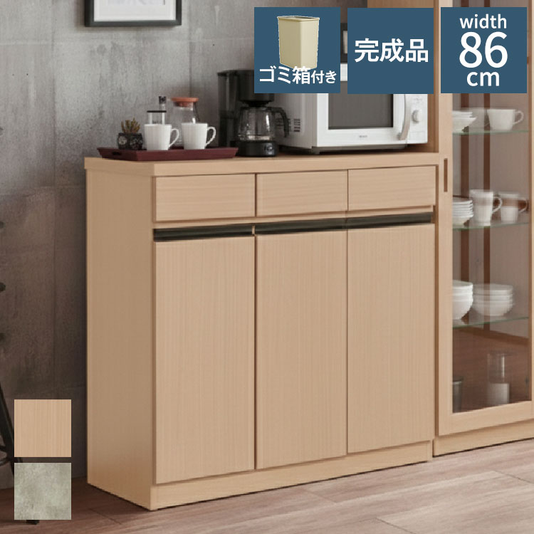 より広いキッチン収納を求める方におすすめしたい、キッチンカウンターペール幅86cmワイドタイプです。家具の町として知られる福岡県大川市で企画・製造された国産の完成品。組立作業なしで届いた日からすぐ使えます。幅86cmのゆとりある天板は、電子レンジ・トースター・炊飯器など複数の小型家電を並べても余裕の広さ。横幅のある分、作業スペースとしても活躍します。カウンター内部には26.5Lのゴミ箱が3個収納できるダストBOX付き。クラップ式で楽々開閉できる設計で、生活感を隠しながら臭いも抑制。天板下には引出しが3杯付いており、お箸・スプーン・フォーク・ラップ・アルミホイルなどもすっきり整理できます。■商品サイズ幅86×奥行39×高さ86cm■素材天板:プリント化粧繊維合板側面:プリント化粧繊維合板■重量32kg■生産国日本■備考付属品:26.5Lゴミ箱×3個■梱包サイズ89×42×88cm【代引きについて】こちらの商品は、代引きでの出荷は受け付けておりません。【商品配送時の注意点】こちらの商品は配送日時の指定ができません。あらかじめご了承下さい。【商品配送時の注意点】本商品は軒先渡しの商品となります。【送料について】北海道、東北、沖縄、離島は送料を頂きます。ゴミ箱付きキッチンカウンター幅58cm幅86cm