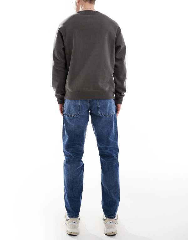 【送料無料】 エイソス メンズ デニムパンツ ジーンズ ボトムス ASOS DESIGN stretch tapered jeans in mid wash Mid wash blue