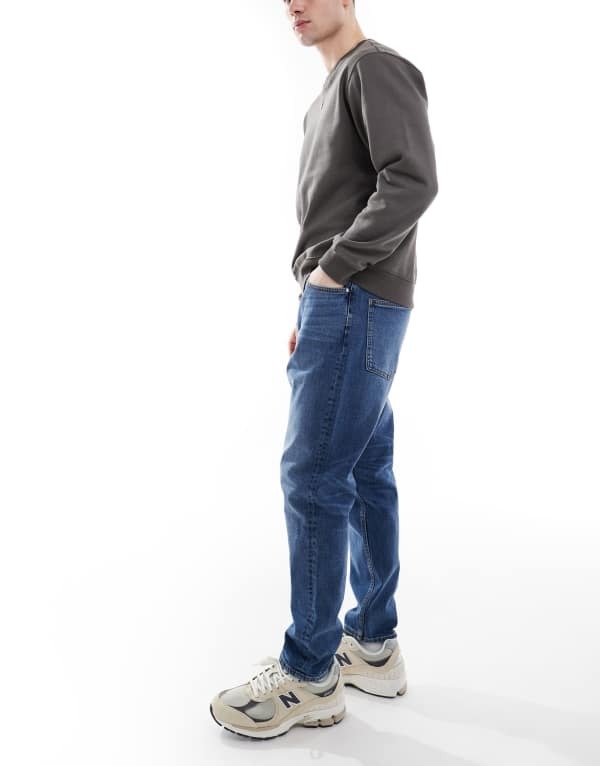 【送料無料】 エイソス メンズ デニムパンツ ジーンズ ボトムス ASOS DESIGN stretch tapered jeans in mid wash Mid wash blue