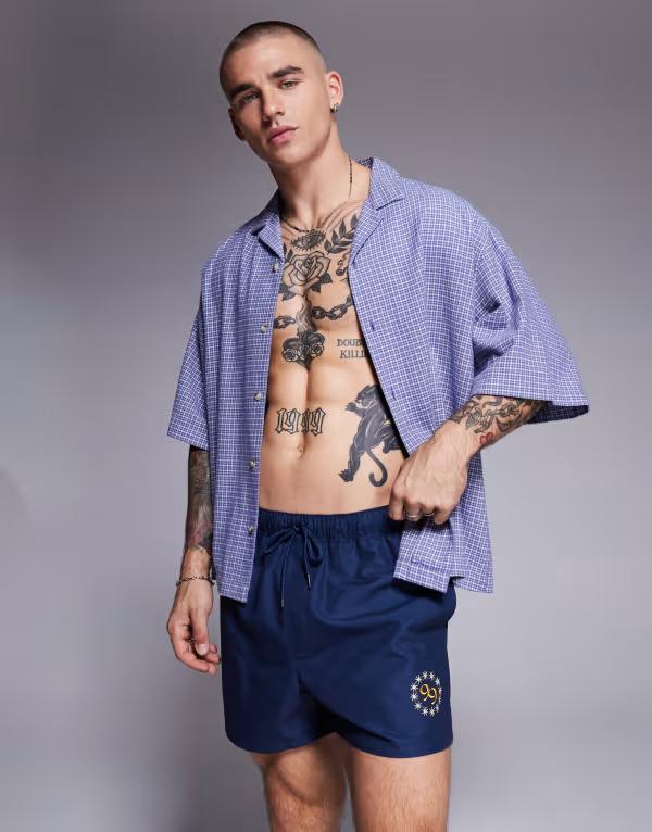 【送料無料】 エイソス メンズ ハーフパンツ・ショーツ 水着 ASOS DESIGN swim shorts in short length with placement print in navy NAVY