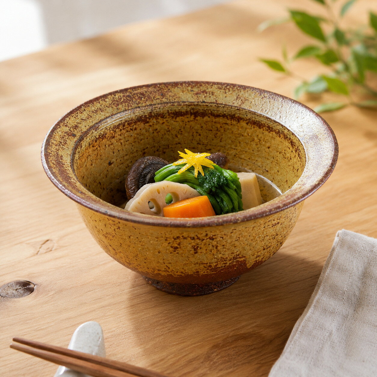 手になじむ「渕折」のフォルムと、深みのある黄金色。 料理を優しく包み込む、伊羅保の実用鉢。 400年の歴史を誇る国指定伝統的工芸品「上野焼（あがのやき）」。 その伝統を守り抜く「渡窯（わたりがま）」による、独特の形状が美しい伊羅保釉の鉢です。 ■アクセントになる「渕折（ふちおり）」の形状 口縁を外側に折り返したような「渕折」のデザインが最大の特徴です。 このひと手間によって器に立体感と陰影が生まれ、シンプルながらも存在感のある佇まいに仕上がっています。また、この縁（フチ）があることで指掛かりが良く、持ち運びしやすいという実用的なメリットもあります。 ■味わい深い「伊羅保（いらぼ）」の景色 全体を包むのは、古くから茶人に愛されてきた「伊羅保釉」。 ざらりとした土の質感と、黄金色や焦げ茶色が入り混じった複雑な色合いが、素朴で温かい「土もの」の魅力を伝えてくれます。使い込むほどに味わいが増し、日々の食卓に静かな落ち着きを与えてくれます。 ■毎日の食卓で活躍する万能サイズ 直径約14.5cm、高さ約7.0cmというサイズ感は、非常に使い勝手が良く重宝します。 一人分の煮物鉢やサラダボウルとしてはもちろん、具だくさんのスープ、または小ぶりな丼（小丼）として、お茶漬けや炊き込みご飯を盛るのにも最適です。 深さがあるため汁気のある料理もしっかり受け止め、和食の定番として長くご愛用いただけます。 ◇スペック◇ ●サイズ：直径約14.5cm × 高さ約7.0cm ●素材：陶土 ●仕様：電子レンジ使用可能、食洗機対応，オーブン使用可能 ※直火不可 （※土の風合いを大切にした陶器のため、手洗いをおすすめします。電子レンジは温め程度なら可能ですが、急熱急冷は避けてください。） ●焼き物：上野焼 ●生産地：福岡県・福智町 ●作りて：渡窯（わたりがま） 【ご注意】 ※手作り品のため、サイズや形状（渕の折り返し具合）、釉薬の色味（焦げ感や濃淡）に個体差がございます。伊羅保特有のざらつきや鉄点も作品の個性としてお楽しみください。 十二代 渡 仁 1968　上野焼宗家渡窯に生まれる 1993　東京造形大学彫刻科卒業　アジア周遊 1994　郷里　上野に戻り　父　久兵衛に師事 1998　西部工芸展入選　以後連続入選 1999　韓国　金沙土器（キムチ甕）にてたたき技法修業 2000　日韓若手作家交展開始　以降2009年まで10度開催 2005　日本伝統工芸展初入選 2007　日本陶芸展初入選　日本伝統工芸展入選 2009　日本陶芸展入選　日本伝統工芸展入選 2010　日本伝統工芸展入選　日本工芸会正会員に認定 2011　日本陶芸展入選　日本伝統工芸展入選 2012　西部伝統工芸展九州朝日放送賞受賞 2012　日本伝統工芸展入選 2013　菊池ビエンナーレ入選 日本伝統工芸展入選 2014　日本伝統工芸展入選　日本橋三越にて個展 2015　日本伝統工芸展入選　菊池ビエンナーレ入選 2016　日本伝統工芸展入選 2017　菊池ビエンナーレ入選 2018　EUジャパンフェスト（オランダ）招待出品 2019　日本伝統工芸展入選 日本橋三越　福岡三越　小倉井筒屋　他　個展■モニターの都合上、掲載写真と実際のカラーが異なる場合がございます。 手になじむ「渕折」のフォルムと、深みのある黄金色。 料理を優しく包み込む、伊羅保の実用鉢。 400年の歴史を誇る国指定伝統的工芸品「上野焼（あがのやき）」。 その伝統を守り抜く「渡窯（わたりがま）」による、独特の形状が美しい伊羅保釉の鉢です。 ■アクセントになる「渕折（ふちおり）」の形状 口縁を外側に折り返したような「渕折」のデザインが最大の特徴です。 このひと手間によって器に立体感と陰影が生まれ、シンプルながらも存在感のある佇まいに仕上がっています。また、この縁（フチ）があることで指掛かりが良く、持ち運びしやすいという実用的なメリットもあります。 ■味わい深い「伊羅保（いらぼ）」の景色 全体を包むのは、古くから茶人に愛されてきた「伊羅保釉」。 ざらりとした土の質感と、黄金色や焦げ茶色が入り混じった複雑な色合いが、素朴で温かい「土もの」の魅力を伝えてくれます。使い込むほどに味わいが増し、日々の食卓に静かな落ち着きを与えてくれます。 ■毎日の食卓で活躍する万能サイズ 直径約14.5cm、高さ約7.0cmというサイズ感は、非常に使い勝手が良く重宝します。 一人分の煮物鉢やサラダボウルとしてはもちろん、具だくさんのスープ、または小ぶりな丼（小丼）として、お茶漬けや炊き込みご飯を盛るのにも最適です。 深さがあるため汁気のある料理もしっかり受け止め、和食の定番として長くご愛用いただけます。 ◇スペック◇ ●サイズ：直径約14.5cm × 高さ約7.0cm ●素材：陶土 ●仕様：電子レンジ使用可能、食洗機対応，オーブン使用可能 ※直火不可 （※土の風合いを大切にした陶器のため、手洗いをおすすめします。電子レンジは温め程度なら可能ですが、急熱急冷は避けてください。） ●焼き物：上野焼 ●生産地：福岡県・福智町 ●作りて：渡窯（わたりがま） 【ご注意】 ※手作り品のため、サイズや形状（渕の折り返し具合）、釉薬の色味（焦げ感や濃淡）に個体差がございます。伊羅保特有のざらつきや鉄点も作品の個性としてお楽しみください。 十二代 渡 仁 1968　上野焼宗家渡窯に生まれる 1993　東京造形大学彫刻科卒業　アジア周遊 1994　郷里　上野に戻り　父　久兵衛に師事 1998　西部工芸展入選　以後連続入選 1999　韓国　金沙土器（キムチ甕）にてたたき技法修業 2000　日韓若手作家交展開始　以降2009年まで10度開催 2005　日本伝統工芸展初入選 2007　日本陶芸展初入選　日本伝統工芸展入選 2009　日本陶芸展入選　日本伝統工芸展入選 2010　日本伝統工芸展入選　日本工芸会正会員に認定 2011　日本陶芸展入選　日本伝統工芸展入選 2012　西部伝統工芸展九州朝日放送賞受賞 2012　日本伝統工芸展入選 2013　菊池ビエンナーレ入選 日本伝統工芸展入選 2014　日本伝統工芸展入選　日本橋三越にて個展 2015　日本伝統工芸展入選　菊池ビエンナーレ入選 2016　日本伝統工芸展入選 2017　菊池ビエンナーレ入選 2018　EUジャパンフェスト（オランダ）招待出品 2019　日本伝統工芸展入選 日本橋三越　福岡三越　小倉井筒屋　他　個展