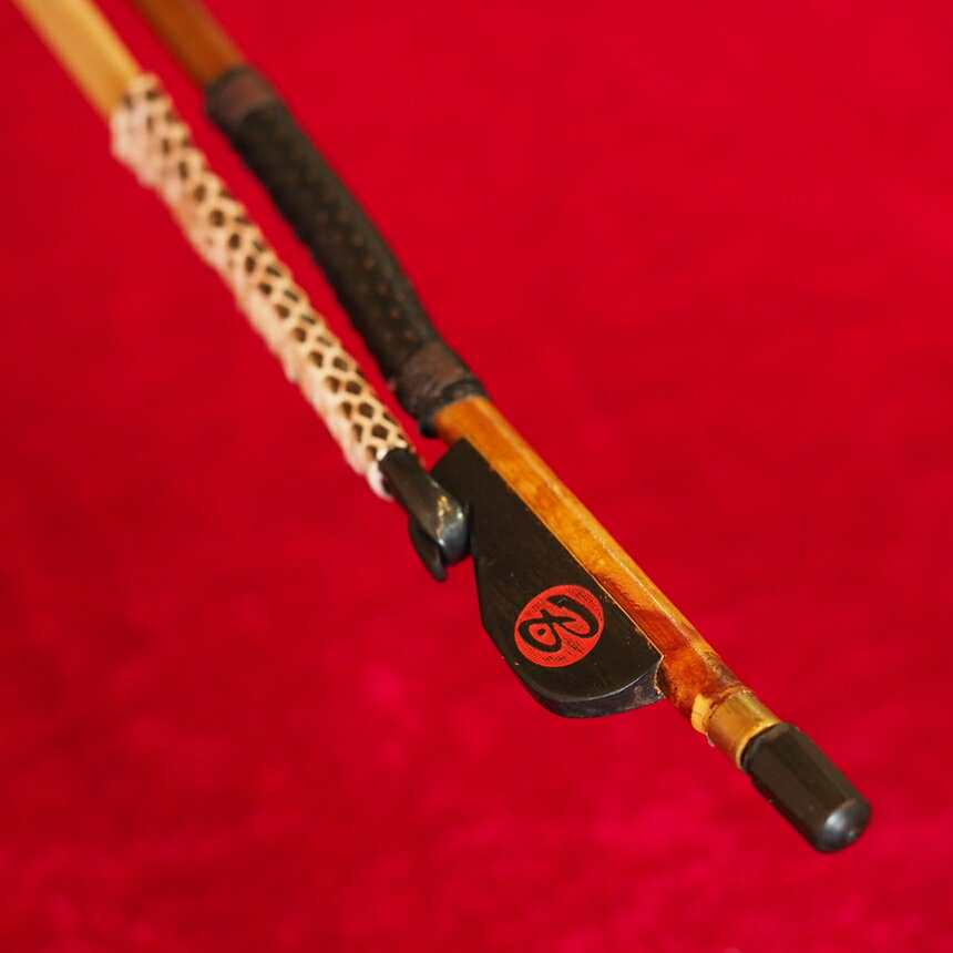 楽器の詳細 特　徴 　二胡専門店red Bridgeと、著名二胡弓製作家・王小迪氏との共同開発により誕生。 　試作と改良を繰り返し、中央音楽学院生、日本人二胡奏者の方々のテストを経て、完成しました。 【无拘音（むぐね）】 　弓竹には、極上のしなやかさを追求して、弓全体に節がない厳選無節竹を採用。弓毛には、最上位の尊品クラス頂級馬尾を使用。 　巻革には、滑りにくく、竹への指あたりを柔らかくするためパンチングした羊皮を使用。 　持ち手部の毛を束ねる管（套管）には、滑りにくさと耐久性を求めて蛇皮を使用。 套管（持ち手部の毛を束ねるチューブ）の長さは、 　■短め：薬指と中指の半分ほどが毛に触れ、弦を摩擦する感覚を感じる（劉長福弓の仕様）。 　■標準：指が毛に触れにくく、従来の指当たり。 の2種類をラインナップ。 ※お使いのモニタの発色具合によって実際のものと色が異なる場合がございます。 特　徴 【この弓の特徴】 　竹　　　　：　厳選無節竹 　弓の長さ　：　約83cm 　毛質　　　：　尊品馬尾（頂級馬尾） 　弓の弾力　：　標準 　套管長さ　：　標準 ※価格を少しでも低く設定するため、発送時は簡易包装（弓はビニル袋に入れ、プラスチック管に入れて発送）とさせていただいております。◆二胡専門店red Bridgeと、著名二胡弓製作家・王小迪氏との共同開発により誕生。 ◆【无拘音】の弓竹には、極上のしなやかさを追求して、弓全体に節がない厳選無節竹を採用。 ◆巻革には、滑りにくく、かつ竹への指あたりを柔らかくするため、パンチングした羊皮を使用。 ◆持ち手部の毛を束ねる管（套管）には、滑りにくさと耐久性を求めて蛇皮を使用。 ◆套管長さは2種類を用意