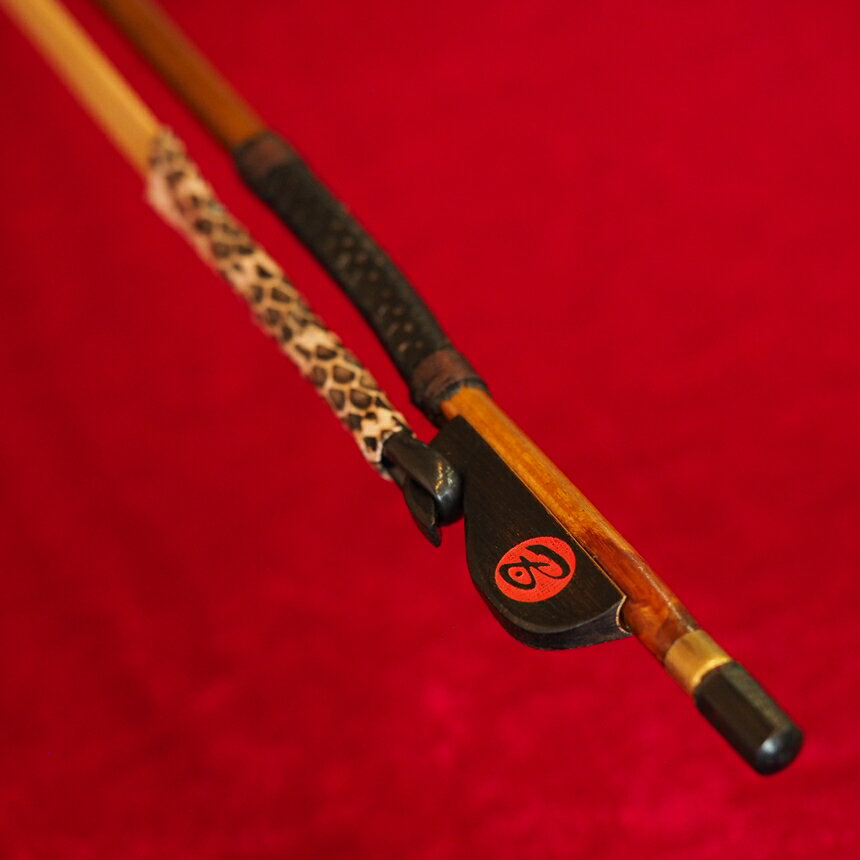 楽器の詳細 特　徴 　二胡専門店red Bridgeと、著名二胡弓製作家・王小迪氏との共同開発により誕生。 　試作と改良を繰り返し、中央音楽学院生、日本人二胡奏者の方々のテストを経て、完成しました。 【无拘音（むぐね）】 　弓竹には、極上のしなやかさを追求して、弓全体に節がない厳選無節竹を採用。弓毛には、最上位の尊品クラス頂級馬尾を使用。 　巻革には、滑りにくく、竹への指あたりを柔らかくするためパンチングした羊皮を使用。 　持ち手部の毛を束ねる管（套管）には、滑りにくさと耐久性を求めて蛇皮を使用。 套管（持ち手部の毛を束ねるチューブ）の長さは、 　■短め：薬指と中指の半分ほどが毛に触れ、弦を摩擦する感覚を感じる（劉長福弓の仕様）。 　■標準：指が毛に触れにくく、従来の指当たり。 の2種類をラインナップ。 ※お使いのモニタの発色具合によって実際のものと色が異なる場合がございます。 特　徴 【この弓の特徴】 　竹　　　　：　厳選無節竹 　弓の長さ　：　約83cm 　毛質　　　：　尊品馬尾（頂級馬尾） 　弓の弾力　：　やや柔らかめ 　套管長さ　：　標準 ※価格を少しでも低く設定するため、発送時は簡易包装（弓はビニル袋に入れ、プラスチック管に入れて発送）とさせていただいております。◆二胡専門店red Bridgeと、著名二胡弓製作家・王小迪氏との共同開発により誕生。 ◆【无拘音】の弓竹には、極上のしなやかさを追求して、弓全体に節がない厳選無節竹を採用。 ◆巻革には、滑りにくく、かつ竹への指あたりを柔らかくするため、パンチングした羊皮を使用。 ◆持ち手部の毛を束ねる管（套管）には、滑りにくさと耐久性を求めて蛇皮を使用。 ◆套管長さは2種類を用意