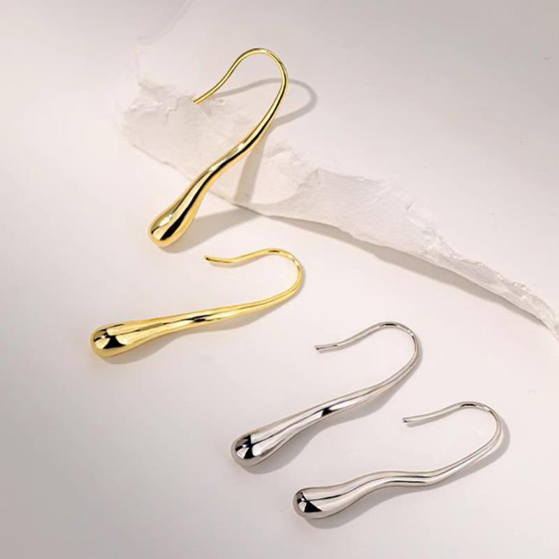 Cute, unique, and simple teardrop-shaped earrings for women. Lightweight, suitable for everyday wear. Features a silver tone, gold-tone bead embellishment, and can be used as an alternative to earrings. A fashion accessory.