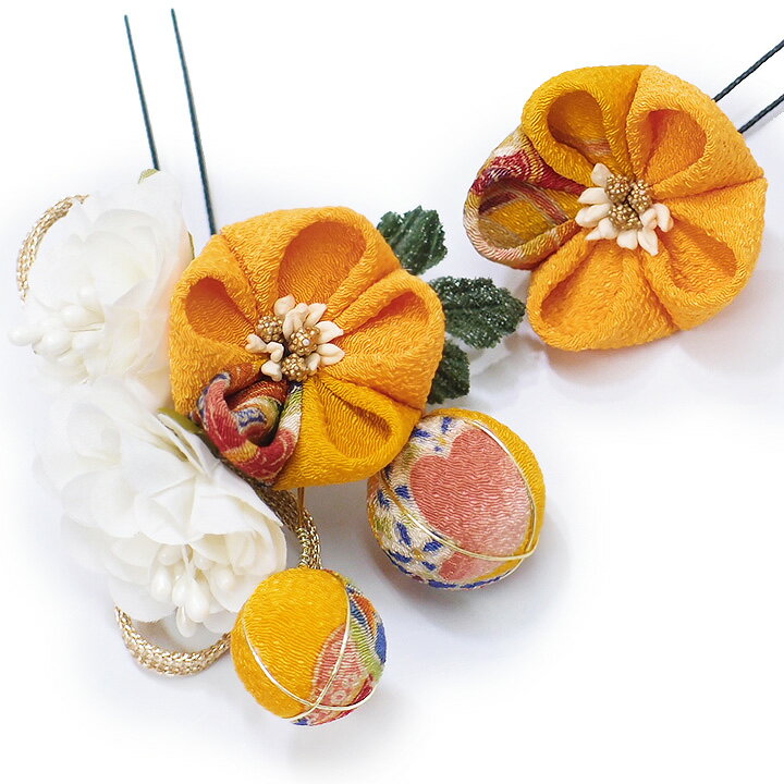 寸法 【大】 横：7cm　縦7.5cm　厚み：3.5cm 【小】 直径：4cm　厚み：1.5cm ※飾り部分のみ計測しています。コーム・Uピンは長さに含まれません。 素　材 ちりめん　金属　Uピン 共箱付き 状態 新品お品です。 お手元に届きましたらすぐにお使いいただけます。 和柄の付き方が若干異なる場合がございます事をご了承ください。 色 明るい山吹色 画像1が実際に近いお色です。 お知らせ 土・日・祝日はお休みをいただいておりますので、 当店からのご連絡は、翌営業日となりますことをご了承ください。 商品説明 成人式の振袖や卒業式の袴などにおすすめの髪飾り！ 華やかなヘアアクセサリーで、晴れの日に特別な装いをお楽しみいただけるお品です。 伝統的なつまみ細工の花にと玉飾りに、白い花と金の組紐が華やかさを感じさせる髪飾りのセットです。 これだけでも十分華やかではありますが、やや控えめな大きさですので、他の髪飾りやかんざしと組み合わせて使うのもの素敵です。 飾りの根元はワイヤーで束ねた作りになっており、お好みの角度に少し曲げてご使用いただけます。 大変豪華でありながら、それでいて派手過ぎる事無く目を惹き、また長くご利用いただけるアイテムです。 2点セットですのでさまざまなヘアアレンジが可能で、左右に分けてつけたり、 あえて片側に寄せてボリュームを出したり、まさに晴れの日にぴったりの髪飾りです。 着脱は簡単安心のUピン式で、どなたにも簡単にヘアアレンジしていただけます。 小さめの飾りは浴衣に合わせても、とっても華やかで、特別感のあるおしゃれを楽しめます。 特に成人式の振袖や、卒業式の袴、結婚式のお呼ばれなど華やかなお着物にオススメです。 髪飾りは、お顔の一番近い部分につけるものですから、とっても目立つ所です。 こちらの髪飾りでしたら、晴れの日の着物スタイルをより一層引き立ててくれることでしょう。