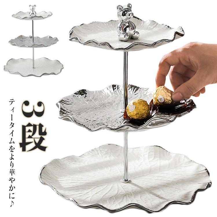 ティータイムをより華やかに♪高級感溢れる蓮の葉をモチーフしたアフタヌーンティースタンドトップには可愛い熊取っ手付きで、持ち運び便利なケーキスタンド。皿は衛生的で上品なセラミック製、いつもお世話になっております清潔に。使わない時は分解してコンパクトに保管できますし、パーツごとに洗えるので衛生面でも安心です♪ サイズ 3段 サイズについての説明 F　25*25*27.5cm 素材 セラミック製 色 写真色 備考 ●サイズ詳細等の測り方はスタッフ間で統一、徹底はしておりますが、実寸は商品によって若干の誤差(1cm～3cm )がある場合がございますので、予めご了承ください。 ●製造ロットにより、細部形状の違いや、同色でも色味に多少の誤差が生じます。 ●パッケージは改良のため予告なく仕様を変更する場合があります。 ▼商品の色は、撮影時の光や、お客様のモニターの色具合などにより、実際の商品と異なる場合がございます。あらかじめ、ご了承ください。 ▼生地の特性上、やや匂いが強く感じられるものもございます。数日のご使用や陰干しなどで気になる匂いはほとんど感じられなくなります。 ▼同じ商品でも生産時期により形やサイズ、カラーに多少の誤差が生じる場合もございます。 ▼他店舗でも在庫を共有して販売をしている為、受注後欠品となる場合もございます。予め、ご了承お願い申し上げます。 ▼出荷前に全て検品を行っておりますが、万が一商品に不具合があった場合は、お問い合わせフォームまたはメールよりご連絡頂けます様お願い申し上げます。速やかに対応致しますのでご安心ください。