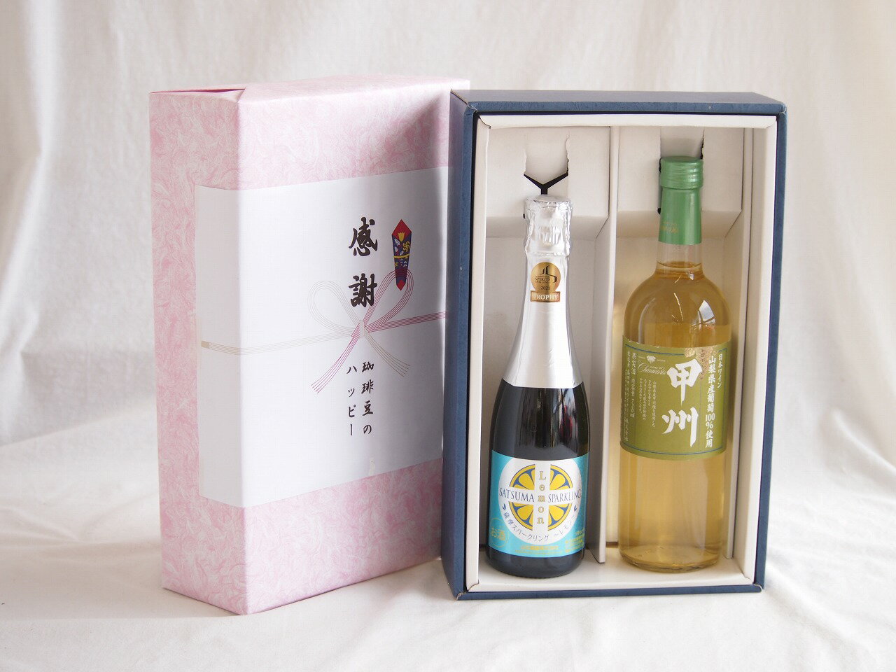 「薩摩スパークリング レモン 8° 375ml」は、鹿児島県の老舗メーカーである**本坊酒造**が造る、リキュールタイプの炭酸入りお酒です。 一般的なレモンサワーとは一味違う、本格派の味わいが特徴です。主な特徴をまとめました。 --- 1. 本格芋焼酎がベースの「深み」 最大のポイントは、ベースに**本格芋焼酎（薩摩焼酎）**を使用している点です。 * 多くのレモンサワーは無味無臭のウォッカや甲類焼酎を使いますが、これは芋焼酎由来の**ふっくらとしたコクと旨味**が土台にあります。 * 芋のクセは抑えつつ、お酒としての飲み応えもしっかり感じられます。 2. フレッシュなレモン感 * レモン果汁を贅沢に使用しており、爽やかな酸味と香りが楽しめます。 * 芋焼酎の甘みとレモンの酸味が絶妙にマッチした、甘すぎない「大人のスパークリング」に仕上がっています。 3. 飲みやすいスペック * **アルコール度数：** 8%（一般的なビールより少し高く、満足感があります） * **容量：** 375ml（シャンパングラスで2杯分ほど。飲みきりやすいハーフボトルサイズ） * **見た目：** おしゃれなボトルデザインなので、ギフトやパーティーの乾杯用にも人気です。 --- おすすめの楽しみ方 * **しっかり冷やしてストレートで** 炭酸が抜けないよう、ボトルごと冷蔵庫でキンキンに冷やし、シャンパングラスやワイングラスに注いで飲むのが一番おすすめです。 * **食事とのペアリング** 後味がスッキリしているので、唐揚げなどの揚げ物はもちろん、薩摩揚げや焼き鳥などの和食とも非常によく合います。 --- 「焼酎はちょっと苦手…」という方でも、レモンの爽やかさで驚くほど飲みやすく感じるはずですよ。 熨斗賜ります。（熨斗表書き例：お中元、お歳暮、内祝いなど お名前例：贈り物本舗じざけや） ギフトカードメッセージ賜ります。感謝の贈り物ボックス瀬戸内産レモン薩摩流の炭酸リキュールと国産ワインセット(山梨県産葡萄100％使用 甲州白ワイン やや辛口(山梨県)720ml信州シャインマスカット＆ナイアガラスパークリング500ml