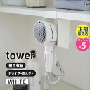 生活雑貨＞洗面用品tower タワー 棚下ドライヤーホルダー ホワイト 5659 05659-5R2 YAMAZAKI (山崎実業)洗濯機上の棚に取り付けて収納できるドライヤーホルダー。YAMAZAKI (山崎実業)商品コード(JAN・EAN・UPC)：4903208056595メーカー型番：LD-TW BE WH05659＜特長＞●ドライヤーは手前からサッと入れるだけの簡単収納。●洗面所の吊戸棚にも浮かせて収納。●接地面にはシリコーンのクッションが付いているから、ドライヤーを痛めません。●コードもまとめてすっきり収納。●棚用フックはマグネットで本体に簡単取付。＜基本情報＞◆サイズ:約W10.8xD8xH27cm◆重量:約480g◆耐荷重:約1kg◆内寸:ホルダー(受け口)/約W10.5xH13.3(有効内寸12.7)cm◆対応サイズ:棚板の厚さ/約1.5〜2.8cm以内、幅/約10.8cm以上、奥行/約8cm+収納するもののサイズ以上◆付属品:クッション(大)x1、クッション(短)x1、クッション(長)x2、粘着テープx1◆カラー:ホワイト◆品質表示:ホルダー・フック/スチール(粉体塗装)、滑り止め/シリコーン、マグネット洗濯機上の棚に取り付けて収納できるドライヤーホルダー。