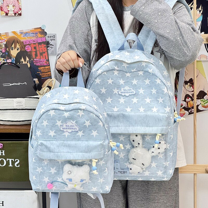 推し活に最適 星柄 痛バッグ リュックサック レディース 軽量 通学用 透明ポケット付き デイパック イベント 女子中学生 高校生 大学生 かわいい バックパック (おしゃれ) 推しのグッズをたっぷり飾れる、星柄デザインが可愛い痛バッグ（リュックサック）です。 【商品説明】推しのグッズをたっぷり飾れる、星柄デザインが可愛い痛バッグ（リュックサック）です。正面の大きな透明ポケットは、推しのぬいぐるみや缶バッジ、アクリルスタンドなどをディスプレイするのにぴったり！イベント参加はもちろん、毎日の通学やお出かけにも使える実用的なバックパックです。ライトなデニム調の素材に、白い星柄（スター柄）を散りばめた日系おしゃれなデザイン。ちょっとしたサブバッグとしても活躍し、機能性とファッション性を両立しました。【商品ポイント】 透明ポケットで推し活を楽しむ：前面に大容量のクリアウィンドウを配置。簡単にデコレーションでき、推しをいつも身近に感じられます。 ユニークな星柄デザイン：カジュアルで可愛らしい星柄（スター柄）が、個性を引き立てます。女子中学生・高校生・大学生のファッションにぴったりです。 軽量で疲れにくい：軽量設計で、教科書やノートパソコン（A4サイズ・13インチ程度のPC対応）を入れても負担になりにくく、通学に最適です。 整理整頓がしやすい：メインポケットの他にも小物入れに便利なポケットがあり、荷物をすっきり収納できます。 5