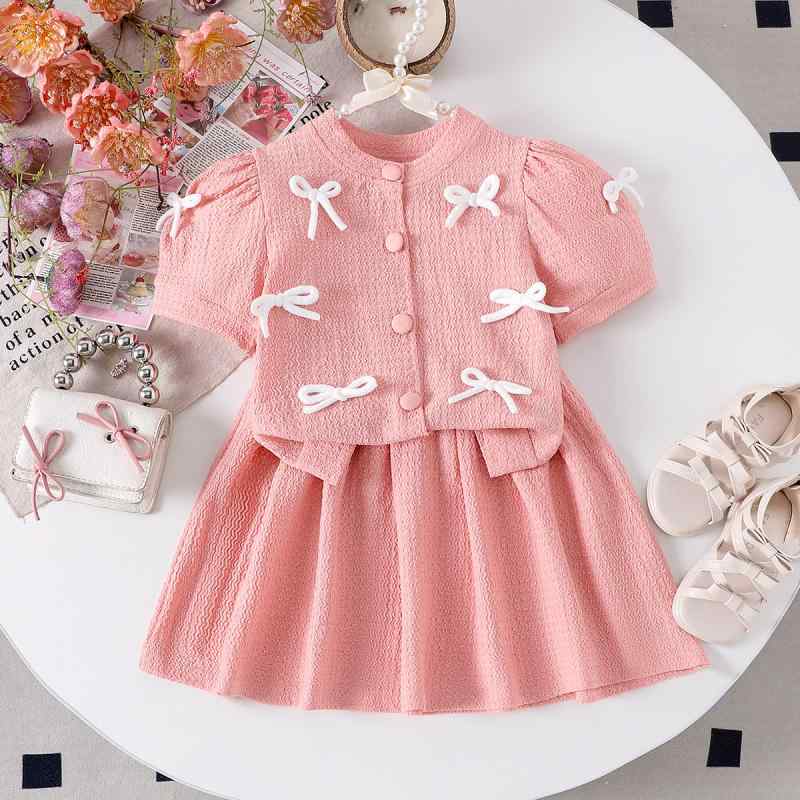 ・カテゴリ: 子供服セットアップ・性別: 女の子・スタイル: 欧米風・セットアップタイプ: スカートセット・セット内容: 2点セット・対象年齢: 3～8歳 (100～140cm)・着用シーズン: 春、夏・袖丈: 半袖・フード: なし・生地加工: 柔らか加工・厚さ: 普通・柄: 無地・デザイン要素: 蝶結び・主な素材: 綿65%、ニット・開閉タイプ: シングルボタン・カラー: コーラルピンク・サイズ展開: 110, 120, 130, 140