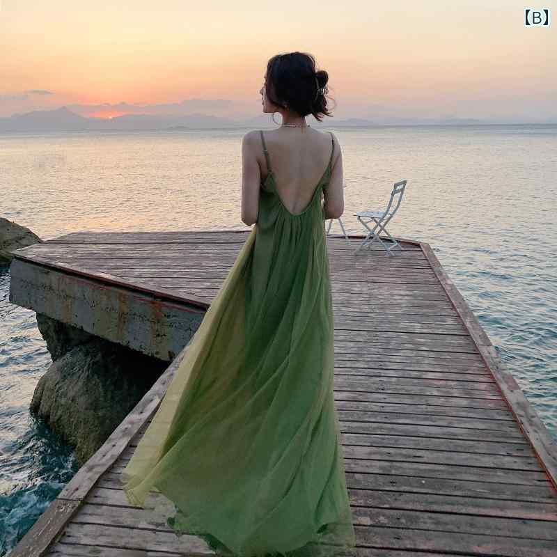 ワンピース ドレス レディース 三亚のビーチで撮影された女性が海辺で休暇を楽しんでいる姿。緑色の砂浜のドレスで、セクシーなバックレスのワンピースドレスで夏のロングドレス。