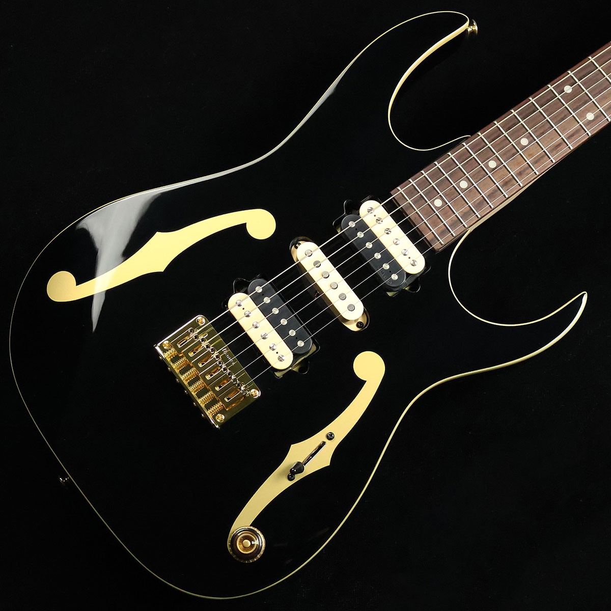 ポール・ギルバートの最新シグネチャーモデル【特徴】これまでにもIbanezから数々のシグネチャーモデルをリリースしてきたポール・ギルバートの最新モデル。ボディ材はナチュラルなサウンド特性を持ったアメリカン・バスウッドを採用。ネックはレスポンスと強度に優れたメイプル&ウォルナットの5ピース構造で握り込みやすいシェイプに仕上げられており、ポジションを問わず優れた演奏性を実現しています。ピックアップはヴィンテージのテイストを追求して設計されたDiMarzioのAir Classicを搭載。ピッキングのニュアンスを的確に捉え表現力豊かなプレイを強力にバックアップしてくれます。【杢目マニア花井のイチオシポイント！】レーサーX〜MR.BIGがドンズバのアラフィフ世代にはもはや説明不要のPGM。こちらのPGM50はMR.BIGの日本ツアー最終公演となった「The BIG Finish FAREWELL TOUR」の中でも度々登場していた最新のシグネチャーモデルです。ボディにfホールがデザインされたお馴染みのルックスですが、ブラックカラーとゴールドハードウェアのコーディネートによってシックかつゴージャスな仕上がりになっています。MR.BIGの節目となるこのタイミングでリリースされたPGM50は、ポール自身にとっても様々な想いが込められた特別な存在になっている事でしょう。この商品についての詳しいお問い合わせは TEL：0570-020-025 または「お問い合わせフォーム」よりお願いします。 【花井's Profile】長野県松本市出身。三度のメシより杢（もく）が好き、自他ともに認める杢目マニア。14年間勤務していた松本店では「ギター生産量日本一」の環境を活かし地元のメーカーや工房とコラボレーションしたショップオーダーモデルなどを多数企画。ギターの製作現場にて数々の職人とミーティングを重ね木材の知識やカスタムオーダーのノウハウを蓄積。これまで培った知識と経験を活かし、彼自身がセレクト〜撮影までおこなったギターをオンラインストアに掲載中。その魅力を全国のギターファンに伝えている。【詳細情報】BODY ： American BasswoodNECK ： 5pc Maple/WalnutFRETBOARD ： RosewoodFRET ： Medium frets（Premium fret edge treatment）TUNING MACHINE ： Gotoh MG-TBRIDGE ： F106 BridgeNECK PU ： DiMarzio Air ClassicMIDDLE PU ： DiMarzio PGMBRIDGE PU ： DiMarzio Air ClassicCONTROL ： 1Vol、5way SwitchSTRINGS ： D'Addario EXL110（.010 - .046）CASE ： Gig BagWEIGHT ： 2.85kgJANコード：4549763349897【mtmt_hni】【kw_HRHM_EG】