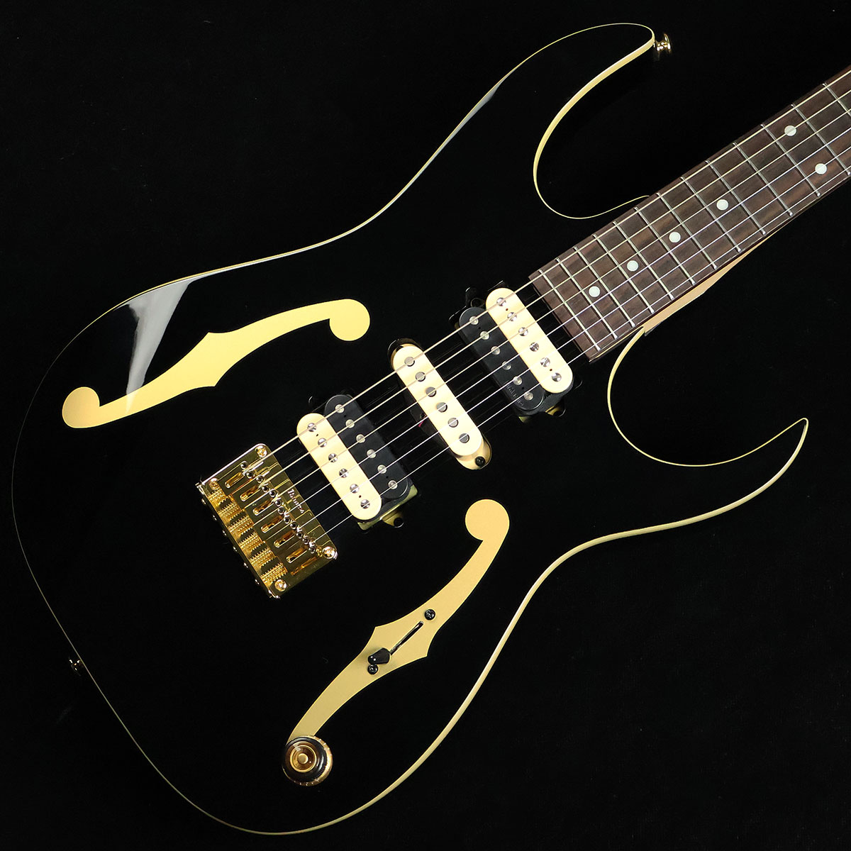 ポール・ギルバートの最新シグネチャーモデル【特徴】これまでにもIbanezから数々のシグネチャーモデルをリリースしてきたポール・ギルバートの最新モデル。ボディ材はナチュラルなサウンド特性を持ったアメリカン・バスウッドを採用。ネックはレスポンスと強度に優れたメイプル&ウォルナットの5ピース構造で握り込みやすいシェイプに仕上げられており、ポジションを問わず優れた演奏性を実現しています。ピックアップはヴィンテージのテイストを追求して設計されたDiMarzioのAir Classicを搭載。ピッキングのニュアンスを的確に捉え表現力豊かなプレイを強力にバックアップしてくれます。【杢目マニア花井のイチオシポイント！】レーサーX〜MR.BIGがドンズバのアラフィフ世代にはもはや説明不要のPGM。こちらのPGM50はMR.BIGの日本ツアー最終公演となった「The BIG Finish FAREWELL TOUR」の中でも度々登場していた最新のシグネチャーモデルです。ボディにfホールがデザインされたお馴染みのルックスですが、ブラックカラーとゴールドハードウェアのコーディネートによってシックかつゴージャスな仕上がりになっています。MR.BIGの節目となるこのタイミングでリリースされたPGM50は、ポール自身にとっても様々な想いが込められた特別な存在になっている事でしょう。この商品についての詳しいお問い合わせは TEL：0570-020-025 または「お問い合わせフォーム」よりお願いします。 【花井's Profile】長野県松本市出身。三度のメシより杢（もく）が好き、自他ともに認める杢目マニア。14年間勤務していた松本店では「ギター生産量日本一」の環境を活かし地元のメーカーや工房とコラボレーションしたショップオーダーモデルなどを多数企画。ギターの製作現場にて数々の職人とミーティングを重ね木材の知識やカスタムオーダーのノウハウを蓄積。これまで培った知識と経験を活かし、彼自身がセレクト〜撮影までおこなったギターをオンラインストアに掲載中。その魅力を全国のギターファンに伝えている。【詳細情報】BODY ： American BasswoodNECK ： 5pc Maple/WalnutFRETBOARD ： RosewoodFRET ： Medium frets（Premium fret edge treatment）TUNING MACHINE ： Gotoh MG-TBRIDGE ： F106 BridgeNECK PU ： DiMarzio Air ClassicMIDDLE PU ： DiMarzio PGMBRIDGE PU ： DiMarzio Air ClassicCONTROL ： 1Vol、5way SwitchSTRINGS ： D'Addario EXL110（.010 - .046）CASE ： Gig BagWEIGHT ： 3.13kgJANコード：4549763349897【mtmt_hni】【kw_HRHM_EG】