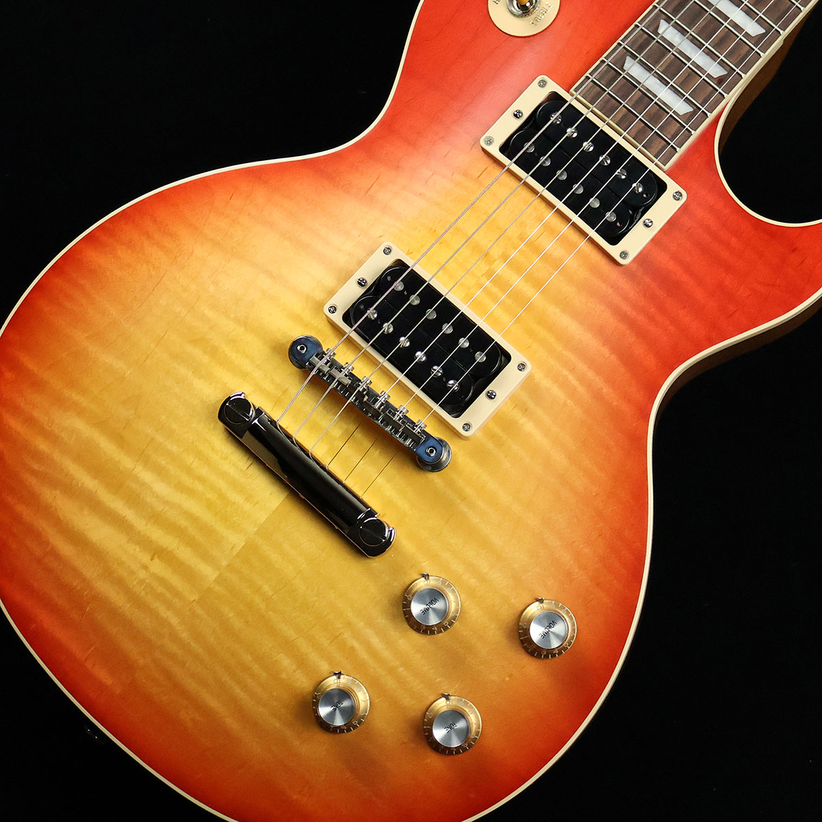 艶のないサテンフィニッシュで仕上げられたLes Paul Standard【特徴】ボディトップにはAAグレードのフィギュアドメイプル、ボディバックにはウェイトリリーフを施さないソリッドのマホガニーを採用。サテン・ニトロセルロースラッカーフィニッシュによって、長く愛用されてきたような味わい深さが感じられるルックスに仕上がっています。ネックは60年代の特徴でもある薄めのシェイプとなっており、ポジションを問わず抜群のプレイアビリティを実現。ピックアップはヴィンテージのテイストを再現した60s バーストバッカーを搭載。透明感のあるクリーントーンから艶やかな倍音を含んだ深みのあるドライブサウンドまで、豊かな表現力が際立つ王道のレスポールサウンドを実現しています。コンデンサーにはお馴染みのオレンジドロップを採用。往年のロックサウンドを求めるギタリストには是非ともオススメしたい仕様となっています。【杢目マニア花井のイチオシポイント！】かつてリリースされていたフェイデッドモデルが待望の復活です。ボディのマテリアルは個性的な杢目を持つAAグレードのフィギュアドメイプルにソリッドのマホガニーという王道のコンビネーション。芯のある重厚な鳴りが持ち味です。この商品についての詳しいお問い合わせは TEL：0570-020-025 または「お問い合わせフォーム」よりお願いします。 【花井's Profile】長野県松本市出身。三度のメシより杢（もく）が好き、自他ともに認める杢目マニア。14年間勤務していた松本店では「ギター生産量日本一」の環境を活かし地元のメーカーや工房とコラボレーションしたショップオーダーモデルなどを多数企画。ギターの製作現場にて数々の職人とミーティングを重ね木材の知識やカスタムオーダーのノウハウを蓄積。これまで培った知識と経験を活かし、彼自身がセレクト〜撮影までおこなったギターをオンラインストアに掲載中。その魅力を全国のギターファンに伝えている。【詳細情報】BODY TOP ： AA Figured MapleBODY BACK ： Mahogany（none Weight Relief）NECK ： Mahogany (Slim Taper)FINGERBOARD ： RosewoodFRET ： 22FSCALE ： 628mmNUT ： Graph Tech（43mm）TUNER ： Grover Rotomatics with Kidney ButtonsBRIDGE ： ABR-1 Tune-O-MaticTailpiece ： Aluminum Stop BarPICKUPS ： 60s BurstbuckerCONTROLS ： 2Vol、2Tone、3Way SW（Hand wired with Orange Drop）COLOR ： Vintage Cherry SunburstSTRINGS ： .010、.011、.016、.026、.036、.046CASE ： HardcaseWEIGHT ： 4.35kgJANコード：0711106095998【gibson】【gbsnmkm_kw】【kw_HRHM_EG】