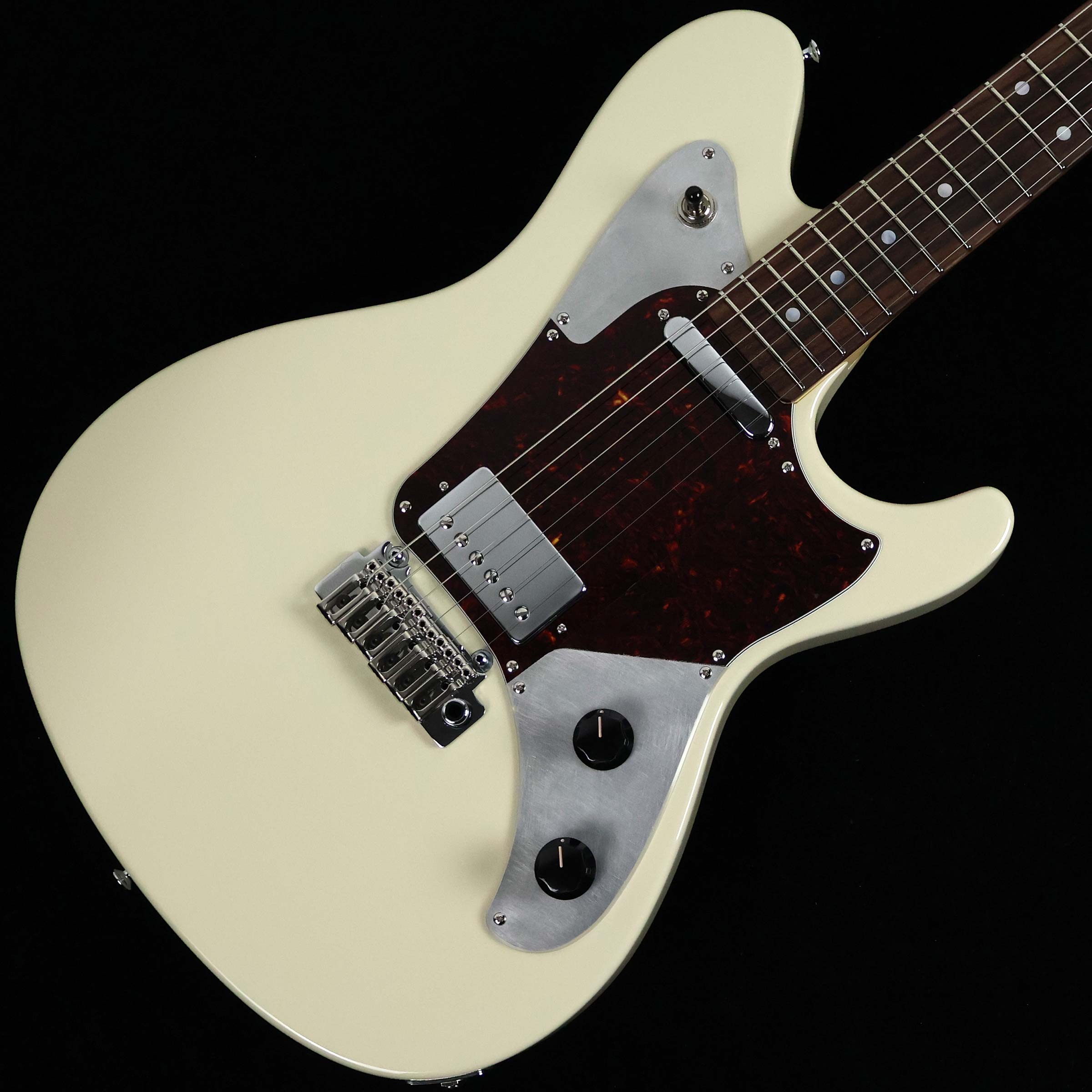 国内のSugi工房で製作されたRainmaker Guitar【特徴】Sugi Guitars代表の杉本 眞氏と旧知の仲であるビルダーTim Wilson氏の工房にて製作されていたUSA製 Rainmakerのコンセプトを踏襲しつつ、細部の仕様を見直し国内のSugi工房にて製作されたMade in Japanのレインメーカー。厳選された上質なマテリアルを贅沢に使用し、国内Sugi工房ならではの丁寧かつ緻密な組み込みで仕上げられた1本。Sugiの代表モデルDS499のボディシェイプに25.5インチスケールのネックを組み込み、ハリのある艶やかなトーンと豊かなサスティーンを生み出しています。ソリッドボディとメイプルネックのコンビネーションによるタイトで歯切れの良い鳴り、程よい”パワー感”と”枯れ”が味わい深いオリジナルのピックアップ。バッキング時のコード感は特筆すべきポイントで、粒立ちの良いドライブサウンドはバンドアンサンブルにおいてもしっかりと存在感を示してくれます。【杢目マニア花井のイチオシポイント！】サウンドメッセ2025でお披露目となった国産の「レインメーカー」。国内のアーティストでも愛用者が多かったUSA製モデルのコンセプトは崩さずに、国内工房ならではのエッセンスを随所に盛り込んで製作されたMade in Japanモデル。Sugi Guitarsというと銘木を使用したゴージャスなモデルに目を奪われがちですが、こういった一見シンプルなモデルにも細部にわたってSugiの「情熱」と「匠の技」が惜しみなく注ぎ込まれており、国内外を問わず数多くのアーティストから絶大なる支持を得ている事も納得です。抜群の弾きやすさと豊かな表現力を兼ね備えた魅力的な1本。ご自身の五感で思う存分ご堪能ください！この商品についての詳しいお問い合わせは TEL：0570-020-025 または「お問い合わせフォーム」よりお願いします。 【花井's Profile】長野県松本市出身。三度のメシより杢（もく）が好き、自他ともに認める杢目マニア。14年間勤務していた松本店では「ギター生産量日本一」の環境を活かし地元のメーカーや工房とコラボレーションしたショップオーダーモデルなどを多数企画。ギターの製作現場にて数々の職人とミーティングを重ね木材の知識やカスタムオーダーのノウハウを蓄積。これまで培った知識と経験を活かし、彼自身がセレクト〜撮影までおこなったギターをオンラインストアに掲載中。その魅力を全国のギターファンに伝えている。【詳細情報】BODY ： Alder 2PBODY FINISH ： UrethanNECK ： Hardrock MapleFINGERBOARD ： Indian RosewoodNECK FINISH ： UrethanNECK SHAPE ： Symmetry ShapeRADIUS ： 250RFRET ： Jescar FW55090 NSTUNING KEY ： Gotoh SG381-05 H.A.PBRIDGE ： Gotoh VG300PICKUPS ： Sugi Original TL800／LH-62PCONTROL ： 1Vol、1Tone（Tap）、3Way SWSCALE ： 648mm (25.5")COLOR ： Vintage WhiteCASE ： Semi Hard CaseWEIGHT ： 3.49kgJANコード：2370000697691【mtmt_hni】