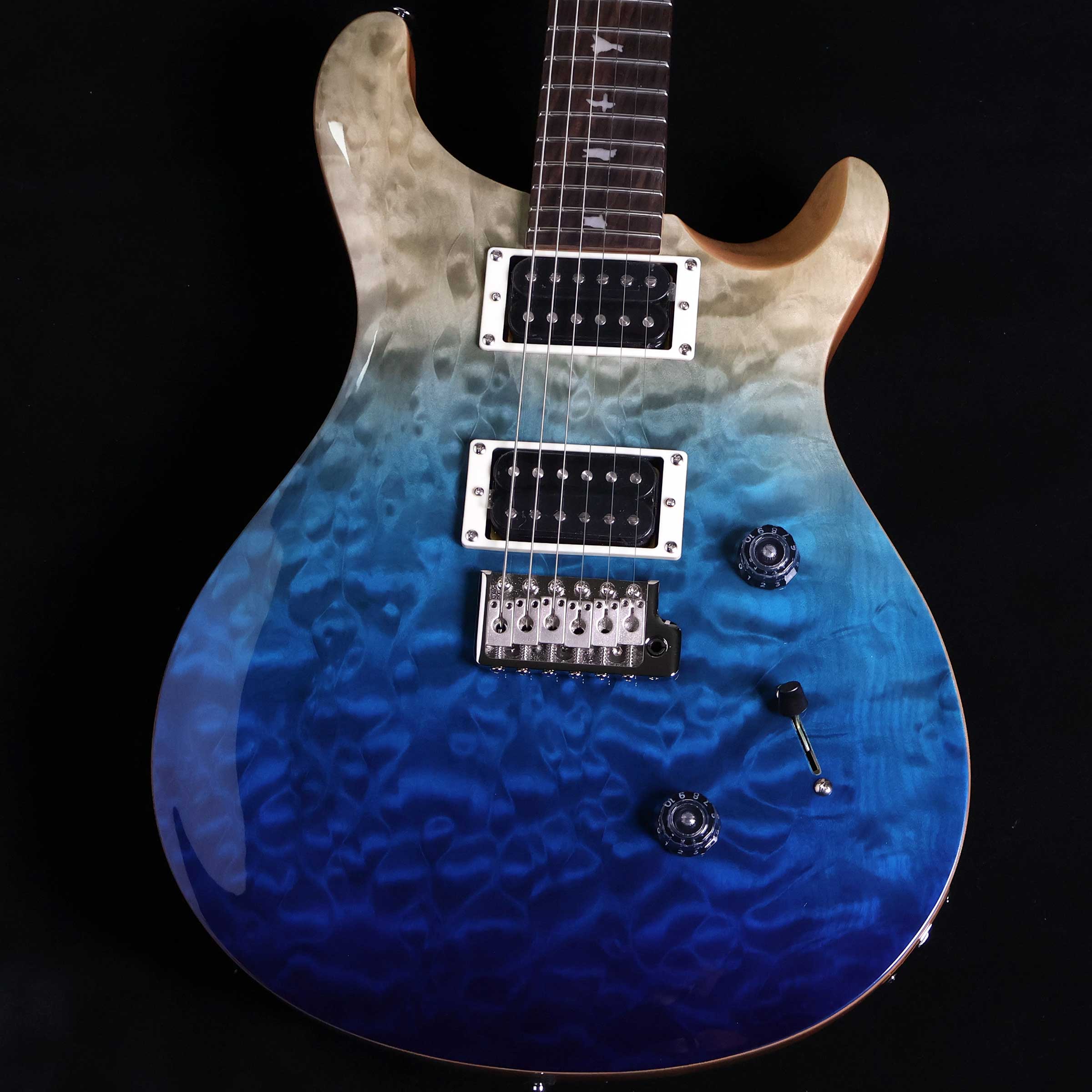 SE Custom24 Quilt Blue Fade S/N:CTIH013448【特徴】数多くのミュージシャンから愛用されているSE Custom 24は、マホガニー・バック、メイプル・トップのボディ、Wide Thinカーブのメイプル・ネック、ローズウッド指板、バード・インレイを合わせ、PRSデザインのトレモロ・ブリッジを装備。ボリューム、プッシュ/プル・タイプのトーン・コントロール、3ウェイ・ブレード・ピックアップ・セレクターを備えた85/15 “S”を搭載し、低音から高音まで明瞭で美しいサウンドが得られます。 SE Custom 24は、クラシカルな中にモダンさを兼ね備え、高い耐久性、多彩なトーンを兼ね備えた1本です。＊保証を受ける条件として、PRS製品の新品購入日から起算して30日以内に【PRS製品登録】、またはメールでの「PRS製品登録」を完了いただく必要がございます。【商品のコンディション】新品・未展示品・現品画像掲載こちらの個体は専任担当者による出荷前の弦交換、オイルトリートメントによる指板保湿、ネック調整後最適な弦高でお届けする安心の画像現物個体販売品です。【担当者コメント】日本市場限定で生産されたキルトトップのブルーフェイド。ブルーからグリーンにフェイドしていく絶妙なカラーに仕上がっています！ランプシェードノブにアップグレードされた個体です。この商品についての詳しいお問い合わせは TEL：0570-020-025 または「お問い合わせフォーム」よりお願いします。【詳細情報】Body Construction : SolidbodyVeneer : Quilt MapleTop Wood : MapleBack Wood : MahoganyTop Carve : Shallow ViolinNumber of Frets : 24Scale Length : 25"Neck Wood : MapleNeck Construction : Multi-PlyTruss Rod : PRS Double-ActingNeck Shape Wide : ThinNeck Depth At The Nut : 13/16"Width Of Fretboard At The Nut : 1 11/16"Width Of Fretboard At The Body : 2 1/4"Fretboard Wood : RosewoodFretboard Radius : 10"Fretboard Inlay : BirdsHeadstock Logo : Signature "SE"Neck/Body Assembly Type : SetBridge : PRS Patented Tremolo, MoldedTuners : PRS Designed TunersHardware Type : NickelNut : PRSTruss Rod Cover : "Custom"Treble Pickup : 85/15 “S”Bass Pickup : 85/15 “S”Controls : Volume and Push/Pull Tone Control with 3-Way Blade Pickup Switch重量：3.41kg付属品：ギグケース、トレモロアーム、レンチ、保証書【ご注意】●メーカー保証付き。メーカー保証期間終了後も島村楽器全店で通常よりもお安く修理、調整いたします。●この商品についての詳しいお問い合わせは TEL：0570-020-025 または「お問い合わせフォーム」よりお願いします。●こちらの商品はミ・ナーラ奈良店でのみ現物をご確認いただけます。未展示品のためご希望の方はミ・ナーラ奈良店スタッフまでお申し付けください。●売却時の商品情報の削除は迅速を心掛けておりますが、万一ご注文後に売り切れとなっておりました場合は誠に申し訳ございませんがご容赦ください。●商品によって、調整等でお届けにお時間をいただく場合がございます。予めご了承ください。■管理コード:0138000881913