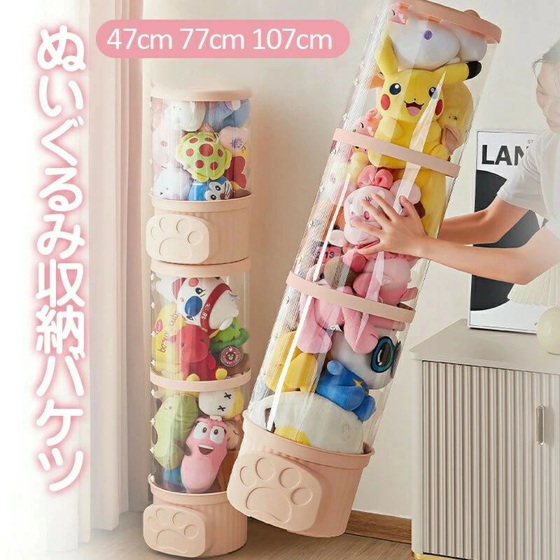 ★★★商品仕様★★★ ●サイズ：直径26cm×高さ47cm ●サイズ：直径26cm×高さ77cm ●サイズ：直径26cm×高さ107cm ●猫の耳部分高さ2.5cm、ふた直径26cm、取り出しよう下部間口18×11.5cm ★★★特徴★★★ ●【簡単組立ての収納筒】PETバケツの体とPPバケツの蓋を使用した縫い包み収納筒。半製品素材で、保護フィルムを剥がして簡単に組み立て可能。升級カード扣で安定感アップ。ぬいぐるみだけでなく、小物収納にも最適。 ●【透明なディスプレイケース】おもちゃの陳列棚としても活躍する透明なぬいぐるみケース。防塵性と防湿性に優れ、お気に入りのぬいぐるみを清潔に保ちながら展示できます。 ●【大容量で積み重ね可能】ぬいぐるみ収納に最適な大容量の縫い包み収納円柱。おもちゃの出口が上下に2つあり、複数のバケツを積み重ねてスペースを有効活用。子供部屋の整理整頓に貢献し、部屋を広々と使えます。 ●【多機能な収納棚】ぬいぐるみだけでなく、洋服も収納できる縫い包み収納縦型棚。部屋の収納力を倍増させ、常に整理整頓が可能。透明なので、中身が一目でわかり、取り出しやすいです。 ●【防湿・防塵】 このぬいぐるみ収納透明ケースは、埃や湿気から大切なぬいぐるみを守るために設計しています。 ★★★ご注意★★★ ※測る位置によって、±1〜2cmの誤差が生じる場合がございます。 ※掲載の商品画像と実際の色は、室内、室外での撮影の状況、モニターの表示等により若干異なる場合がありますので、ご了承ください。 ※製品の仕様は品質の向上・改善のため、予告なく変更となる場合があります。 ※海外輸入品のため、輸送・検品時に汚れやキズがつく場合がございます。ご使用に支障のない程度につきましてはご了承ください。 ※エコの観点から簡易包装を行っております。商品によっては外箱に直接伝票を貼り付けて発送することがございます。ラッピング包装は承っておりません。ご了承ください。