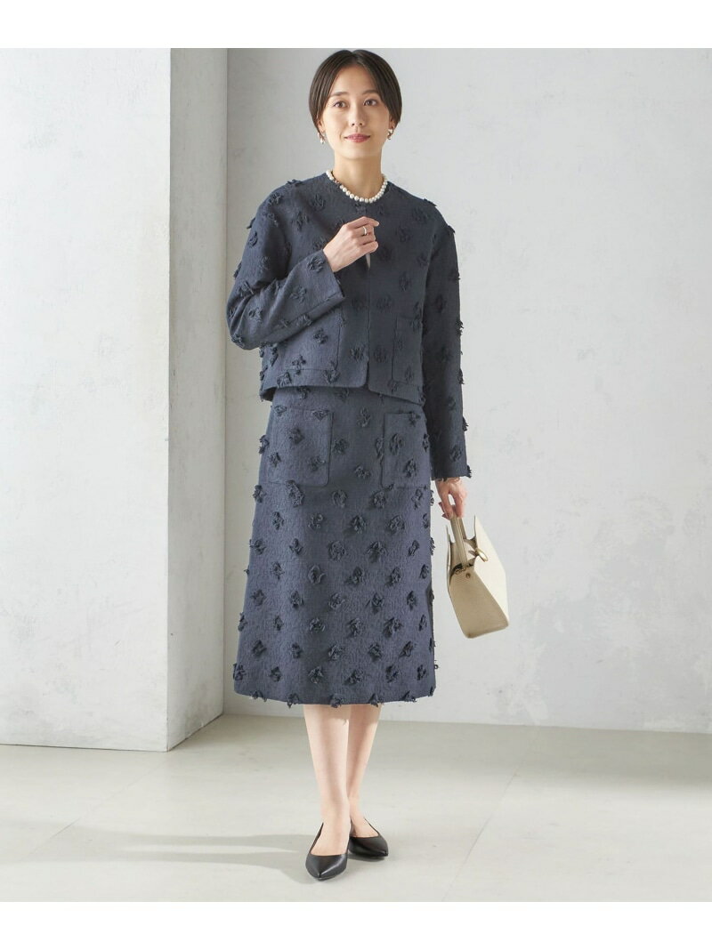 立体感のあるジャカード素材が、より華やかな雰囲気を醸し出すセットアップ。素材にポイントがあるから、シンプルなニットやカットソーですっきりと仕上げるのがおすすめです。
アウトポケットがヒップまわりをカバーしてくれるAラインのスカートは、ミディ丈でクラシックなムードが漂います。