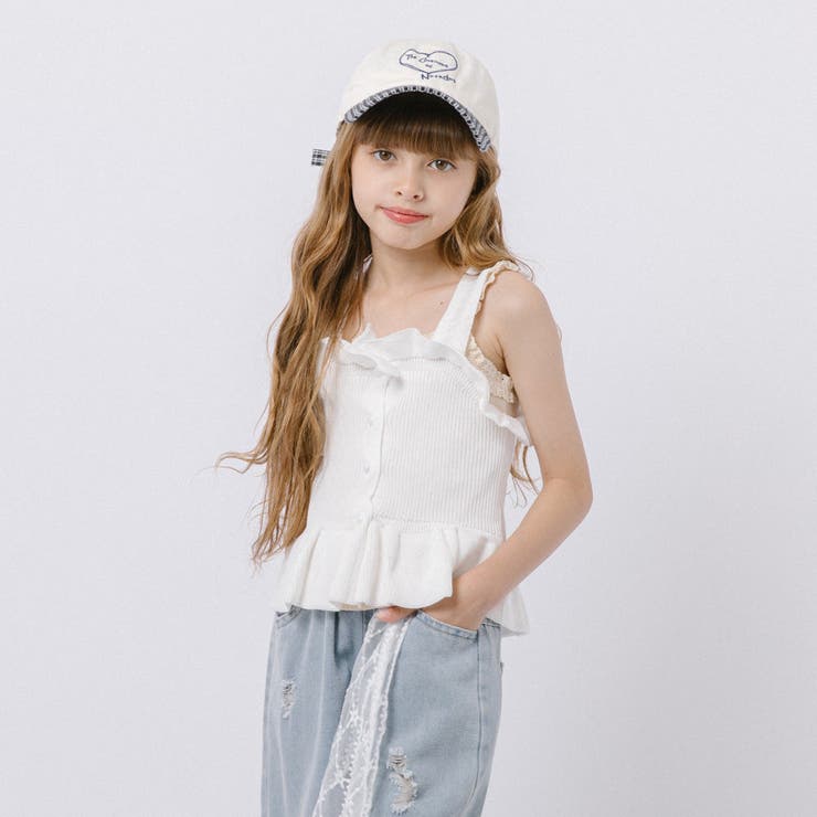 胸元と裾にあしらわれたフリルが目を惹く、女の子らしいノースリーブトップスです。コンパクトなシルエットにペプラムデザインを組み合わせ、一枚で華やかな着こなしを楽しめるアイテムに仕上げました。フロントの小さなパール調ボタンや、胸元を囲むフリルが上品なアクセントに。裾へ向かってふんわり広がるペプラムシルエットが、やさしく可愛らしい印象を演出してくれます。伸縮性のあるニット素材を使用し、身体にほどよくフィットしながら快適な着心地を叶えます。やわらかな編み地で動きやすく、一枚でもレイヤードでも着回しやすいのが嬉しいポイントです。インナーを合わせたり、一枚で着たりと着こなしの幅が広がるのが嬉しいポイントです。デニムパンツやカーゴパンツを合わせてカジュアルに、ティアードスカートやレースボトムを合わせてガーリーに着こなすなど、さまざまなコーディネートを楽しめます。シーズンを問わず着回しやすく、毎日のスタイリングで活躍する一枚です。【おすすめスタイリング】●ガーリーコーデレースインナーやフレアスカートを合わせれば、女の子らしさあふれる上品なコーディネートが完成します。●韓国っぽコーデワイドデニムやキャップを合わせれば、甘さをほどよく取り入れたトレンドスタイルを楽しめます。●カジュアルコーデデニムパンツやカーゴパンツにスニーカーを合わせれば、抜け感のあるデイリーコーデに仕上がります。●通学コーデショートパンツやデニムと合わせれば、動きやすく毎日のおしゃれを楽しめる通学コーデとして活躍します。フリルとペプラムシルエットが魅力のトップスは、一枚でもレイヤードでも幅広い着こなしを楽しめるガーリーなアイテムです。■モデル身長119cm 着用サイズ120cm■サイズ110cm 着丈33 身幅26120cm 着丈35 身幅27130cm 着丈38 身幅28140cm 着丈40 身幅29■商品仕様裏地：ティアード部分のみあり/生地の厚さ：普通/透け感：なし/伸縮性：なし ■素材本体：綿65% ポリエステル35%■対象女の子返品・交換について購入後の交換は受け付けておりません。予めご了承ください。返品を希望される場合は購入履歴一覧の「ショップへの問い合わせ」よりお問い合わせください。=========================複数配送先指定について1件の注文に対して、異なる住所への配送は対応出来かねます。恐れ入りますが、異なる住所へ配送をご希望の場合、配送先毎に分けて注文いただきますようお願い申し上げます。【トップスKIDS】ホワイト ブラック ピンク 110cm 120cm 130cm 140cmホワイト ブラック ピンク