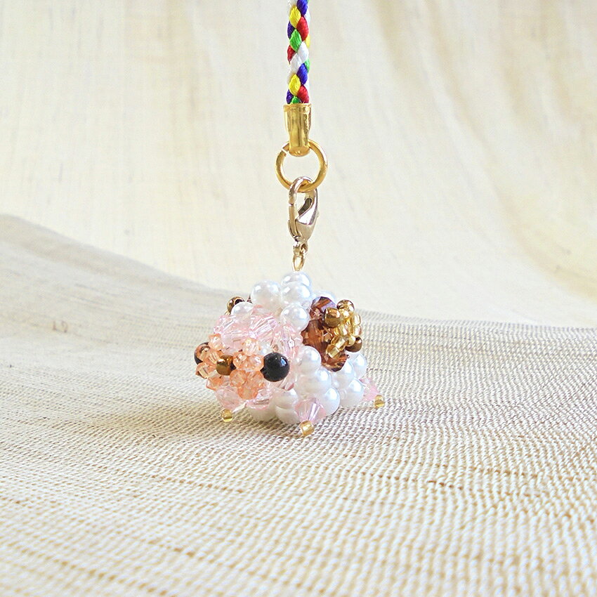 ■サイズ（約）… 　未（ひつじ）…3.5×2.5×2.5cm 　全長…11.5cm（根付金具含む） ■セット内容…ビーズ（アクリルビーズ・丸小ビーズ）、パール、鈴、カニカン、テグス、根付金具、作り図 ■用意するものハサミ、ラジオペンチ、定規、ボンド、目打ち ■難易度…★★☆☆☆ ■制作時間目安…約60分 干支の「未」にちなみ、新しい一年が何事もなく平穏で、安らかに過ごせますようにという心温まる願いを込めて仕立てる、テグス編みビーズキットです。 コロンとした丸いフォルムに、パールの優しい輝きが羊ならではの「もこもこ感」を表現。 干支の縁起物としてはもちろん、シーズンを問わず毎日身につけたくなる愛嬌たっぷりの一品です。 お財布やかばん、ポーチなどに付けて、日々の暮らしにほっこり癒やされるお守りとしてぜひお役立てください。 ※メール便可能です。 メーカー希望小売価格はメーカーカタログに基づいて掲載していますビーズキット あんのんひつじの根付け BK-160【メール便可】
