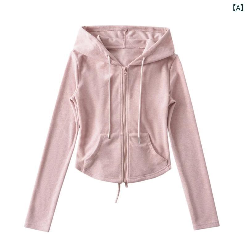 ギャルは ウエストを 締めて 帽子 付きの パーカーの コートを 持って います。