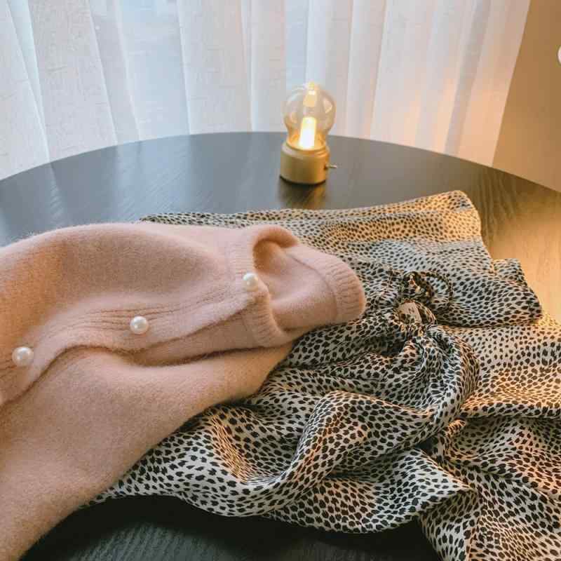 多色 入りの 浅い ガチョウの 黄色の 真珠は 春に 底を 打って 厚い ニットの カーディガンの 女性の 短い 丸首の 中で セーターの コートを 掛けます。