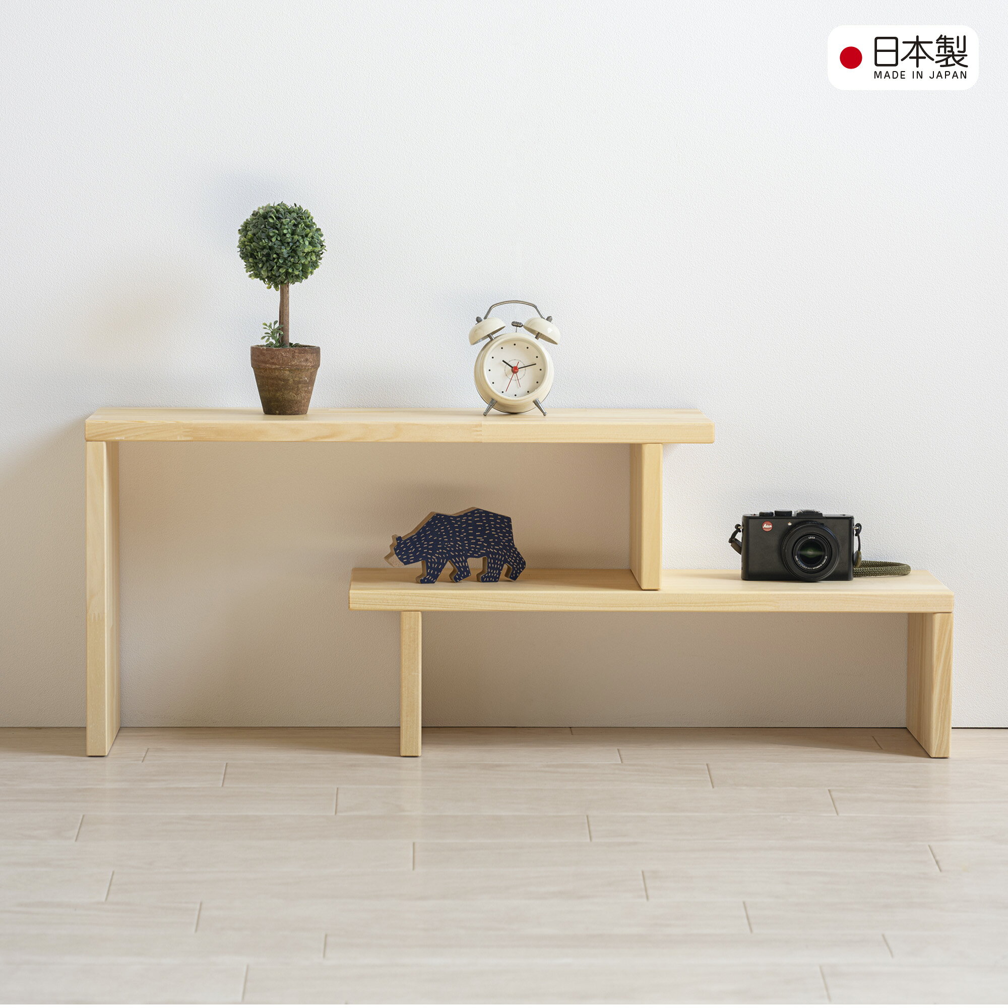 主　材 メルクシパイン材（集成材） サイズ 上段　W600×D200×H320mm 下段　W579×D200×H160mm 耐荷重 約20kg ※2つの棚の固定はできません。すべり止めでズレにくくはなっていますが、ギリギリでご使用される際はご注意ください。 特　徴 　奥行き20cmのスリム設計で、設置場所にあわせて置き方を変えることができる「伸縮フリーラック」。デスクトップやリビングのちょっとしたスペースにもすっきり収まります。素材には木目のかわいいメルクシパイン（集成材） を使用。置き方を変えることができるので、お部屋の雰囲気に合わせてコーディネートが可能です。シンプルながらも上品なデザインで、マルチな活躍してくれる一台です。 付属のすべり止めを8箇所に取りつけて使用します。 ・完成品 ・生産国：日本