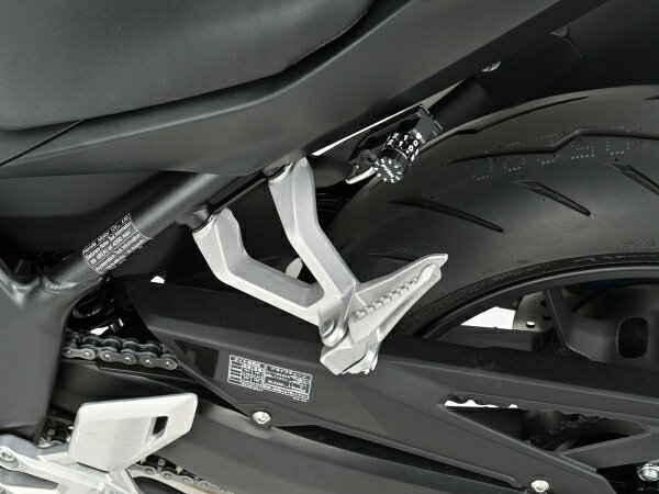 キー不要のダイヤルロックタイプ 車種専用設計のダイヤル式ヘルメットホルダー。 左側タンデムステップホルダーと共締めで簡単装着できます。 タンデム時も足に引っかからない位置にあるので装着しても違和感がありません。 2ダイヤルロック式で、任意の番号に設定可能。 ダイヤルリングの数字が見えなくても、リングの突起とボタンの数字を合わせればワンプッシュで解錠できます。 【意匠登録 No.177691】 ・カラー：ブラック ・素材：スチール（ステー） ・解錠する数字は任意で変更可能。2ダイヤルロック式。 ※駐車中のヘルメットの盗難を抑止する商品です。ホルダーにヘルメットを装着したままの走行は危険ですのでお止めください。 ※この商品は盗難やイタズラを抑止するものであり、完全な盗難防止を保証するものではありません。装着した物の盗難、紛失、脱落、破損、故障に関しましては一切補償いたしかねます。あらかじめご了承ください。 【適合車種】 【HONDA】 車種：CBR400R FOUR E-Clutch 年式型式：2026＜NC70＞