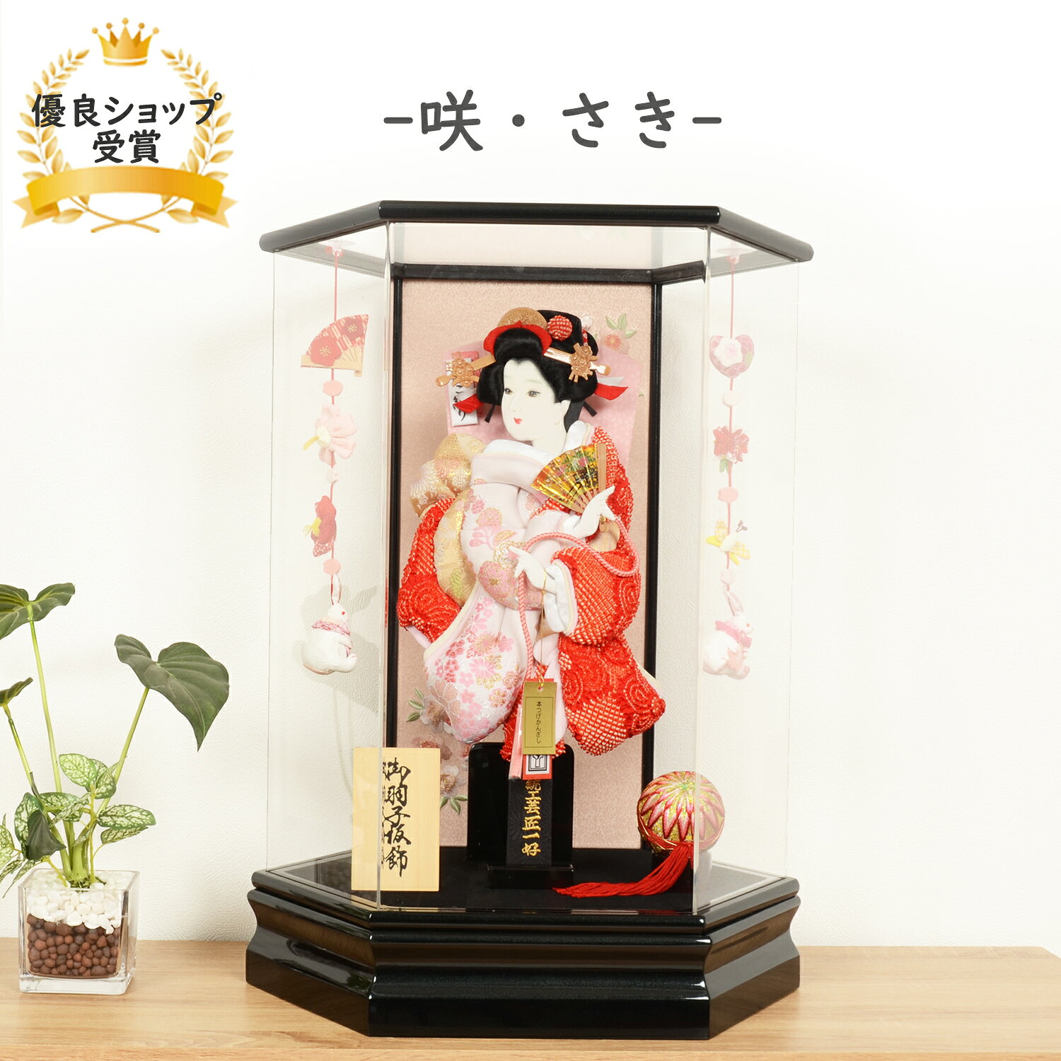 商品情報羽子板8号 名人「匠一好」作 オリジナル羽子板ケース13号咲・さきサイズ間口40×奥行32×高さ55【cm】商品詳細【 送料無料 お正月セットプレゼント】「匠一好」の繊細で複雑なデザインは「節句人形工芸士」の筆頭といっても過言ではありません。 ケースは、すべての面に高級な強化アクリルを採用。たいへん軽く、女性の方でも楽に出し入れができます。江戸時代から受け継がれている羽子板とは邪気や悪いものをはね（羽根）のけ、女の子が健やかに成人するようにという願いを、優雅で華麗な装飾を施した羽子板に託した、お正月飾りの贈り物です。厄除けや魔除けの品として飾り、子どもの健康を願っていたのです。注意事項お名前木札に入れるお名前は・生年月日の記載漏れにご注意下さい。お客様のモニター等の環境により多少色合いが異なる場合がございます。また、商品は、全て一つ一つ手作り品のため、お届けする品の模様配置等が画像掲載品と多少異なる場合がございます。ご理解いただけますようお願い申し上げます。羽子板 インテリア デザイン 正月 ミニサイズ コンパクト 手書き面相 【 13号 咲・さき 】可愛い おしゃれ かわいい インテリア 匠一好 【レビュー特典木札・お手入れセット付・送料無料】六角の上品で可愛らしい、羽子板ケース飾り 「匠一好」の羽子板は、伝統的な有名ブランドです。繊細な筆使いや、複雑なデザインは「節句人形工芸士」の筆頭といっても過言ではありません。こちらの羽子板は、オリジナルで制作し洋室にも馴染み、インテリアとの相性も抜群です◎。アクリルケースは、たいへん軽く、女性の方でも楽に出し入れができます。 2