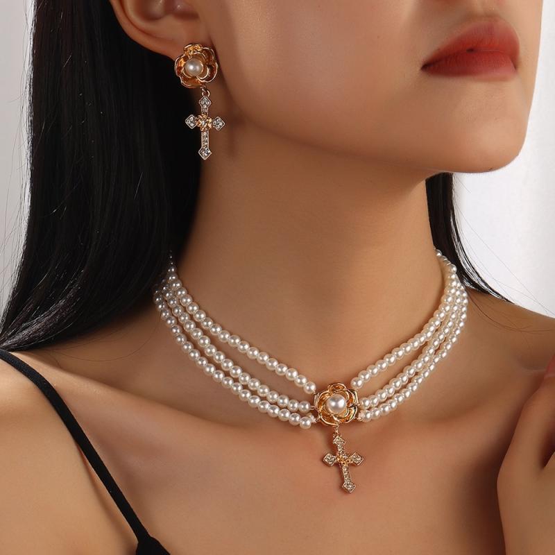 Ladies' accessories and jewelry set: necklace and earrings with pearls, cross motif, sparkling rhinestones, electroplated finish. Unique and glamorous, perfect for special occasions, parties, and after-parties. European and American style fashion accessories.