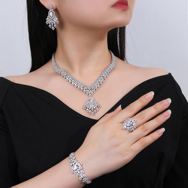 Women's 4-Piece Jewelry Set: Necklace, Earrings, Bracelet, and Ring. Electroplated, hypoallergenic, luxurious accessory set perfect for weddings, receptions, parties, and recitals. Features a floral pattern and white gold finish.