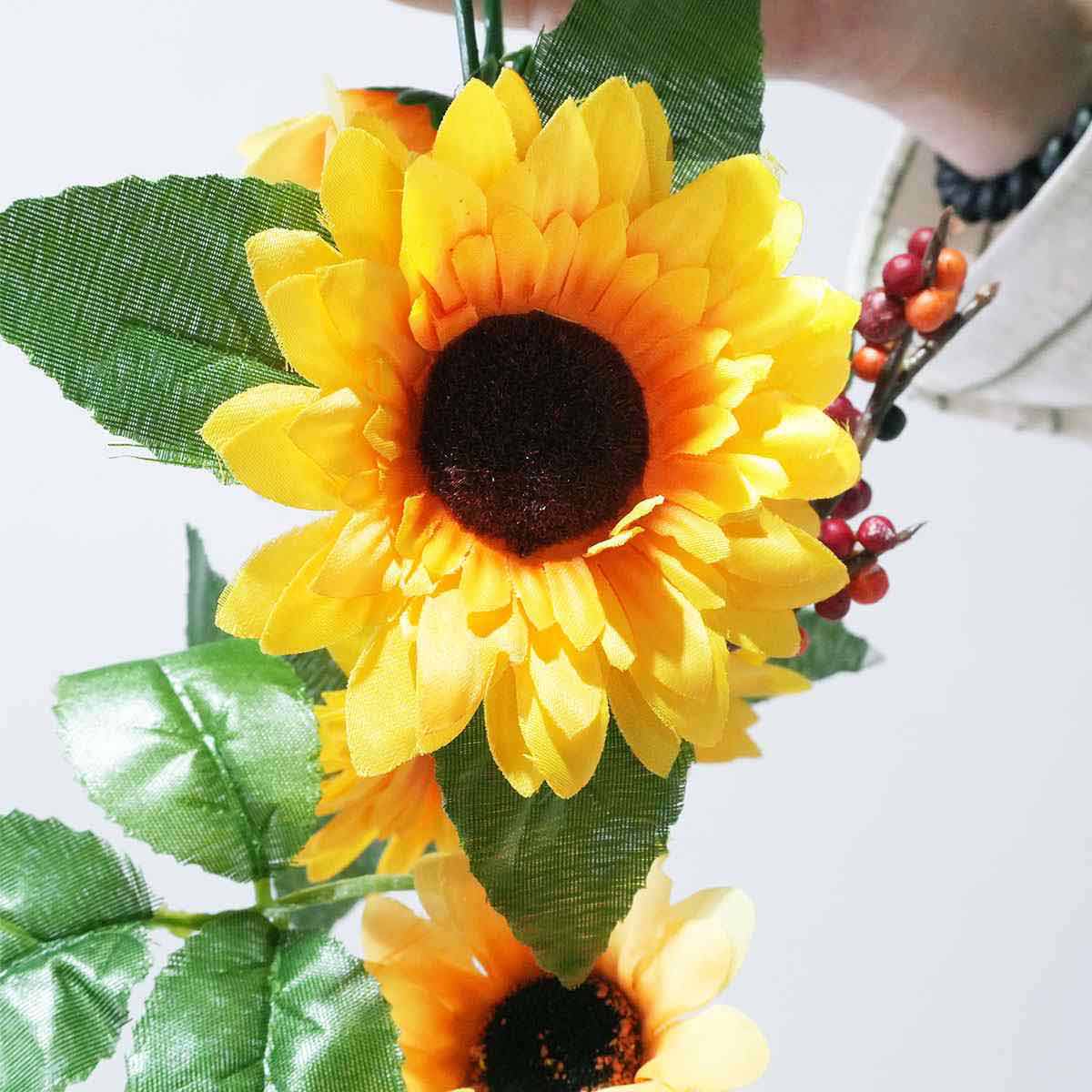 ひまわりガーランド デラックス花径7〜10cmの向日葵の花がたくさん付いており、全体長さ180cmのガーランドです。壁に吊るしたり、ディスプレイテーブルに置いたり。夏の装飾にピッタリです。造花 おしゃれ ひまわり ヒマワリ インテリア 壁掛け 吊り下げ 3