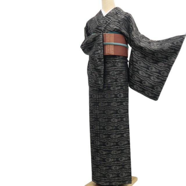 商品説明 これは、チャレンジしたい。。。大人の品を持つ幾何学模様。 徳川十一代将軍家斉が好んで召されたことならその名が付いたとされるお召は、御召縮緬の略称で縮緬と同様に緯糸に強い撚りをかけた生糸を使いますが、糸を染色してから織り上げます。独特のしぼを持ち、紬よりも軽く裾捌きもよいので、観劇やお稽古、華やかなパーティーから目上の方へのご挨拶まで幅広くお召し頂けます。 黒×練色で段々と積もるように広がる幾何学模様は、華やかな色を持たずに大人の品を見せつつそこはかとミステリアスな雰囲気を漂わせ、じっくりと追いかければ、短い縞やひし形を上手に操り、見る者の視覚を惑わせる 魅力は健在。幾何学模様をちょっと敬遠していた貴女もこれは、チャレンジしたい。。。と思ったでしょう？ 撮影のため一度着付けた仕付け糸付の真っ新な一品。そう、あなたから始まるお着物。 長身さん必見のトールサイズ、素材は、高級感があり肌当たりもよい正絹。 大人の品を持つ幾何学模様をお届けする、正絹トールサイズお召でございます。 採寸表 身丈 ： 168cm（肩から） 裄　 ： 67.5cm 肩巾 ： 33cm 袖巾 ： 34.5cm 袖丈 ：49 cm 前巾 ： 25cm 後巾 ： 28.5cm 素材 ： 正絹(袷) 折代 ： 身丈(内揚げ 前6.5cm・後8.5cm)　裄(身頃側：2cm・袖側：4cm)　袖丈(5cm)