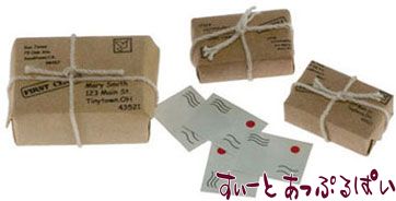 小包とはがきのミニチュアです。なんだか可愛らしいですよね！小包は、木片を紙で包み、紐をかけてあるようです。これを参考に、自作してみるのも楽しそうですね！ドールハウスの様々なシーンでお役立てくださいね。大きな小包のサイズ：30x20xH12mm 、小さな小包のサイズ：21x13xH7mm 。はがき：15x12mm。※はがきは現在3枚になっております。