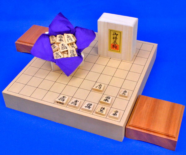 将棋セット　新桂2寸ハギ卓上将棋盤セット(将棋駒黄楊特上彫錦旗書)　 ■将棋盤：卓上将棋盤　新桂2寸ハギ ・将棋盤の材質：木製ハギ造り　新桂材(アガチス材) ・将棋盤のサイズ：横幅33cm×奥行36cm　厚み約6cm ■将棋駒：木製将棋駒　黄楊特上彫　錦旗書 ■将棋駒台：卓上将棋盤用駒台　本桂2寸 ※駒台は本桂材ではなく栓(せん)材になる場合がございます 　卓上将棋盤新桂2寸ハギと木製将棋駒黄楊特上彫錦旗書と卓上将棋盤用駒台本桂2寸との木製将棋盤セットです。卓上将棋盤新桂2寸ハギは新桂材(アガチス材)のハギ造りの厚み2寸の卓上将棋盤です。やや明るめの茶褐色系の色合いです。将棋駒黄楊特上彫錦旗書はシャム黄楊材の錦旗（きんき）書の彫り字の将棋駒です。 ■ハギ造りの将棋盤 　ハギ造りの将棋盤とは、一枚板造りではなく、将棋盤の奥行きの長さがある角材を横に合わせて造った将棋盤の事です。ハギ造りの将棋盤は反り(そり)を防ぐ効果もあります。 　新桂2寸ハギ卓上将棋盤は比較的変形が少なく、将棋盤としては耐久性が強く2寸の厚みの卓上将棋盤でしっかりした硬めの指し味をお楽しみ頂ける卓上将棋盤です。 　指し味を楽しめるお手頃価格の木製将棋駒として昭和時代から定番のシャム黄楊材の将棋駒です。錦旗書は癖の少ないスタンダードな書体で、力強さの中に優雅さも兼ね備えた特上彫書体の中で最も人気がある書体の一つです。 　しっかりした厚みの卓上将棋盤と木製将棋駒黄楊特上彫錦旗書との、指し味と雰囲気をしっかりお楽しみ頂けるバランスの良い新桂2寸ハギ卓上将棋盤セットです。