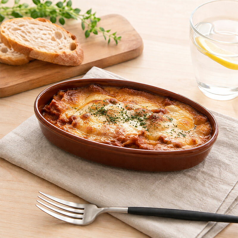 商品説明 食卓に洗練された雰囲気をもたらす落ち着いたブラウンのラザニア皿。 温かみのあるブラウンは焼き料理との相性が良く、より美味しそうに引き立てます。 こちらはラザニアやグラタン、ドリアはもちろん、煮込みハンバーグなどの煮込み料理にもぴったり。 熱々のお料理を食卓に並べることができ、おもてなし料理にも活躍します。 商品詳細 サイズ／19.7×12×高さ3.5cm 重さ／約410g 容量／約320cc(満水) 素材／磁器 質感／つややか 生産地／日本(美濃焼) 電子レンジ・食洗機・オーブン可 直火不可 ※サイズは全て外寸になります。 ※サイズ・重さなどは商品により誤差があります。 ご注意 ※ご注文前に商品の特性・当店の検品基準をご確認ください。 ※お客様のお使いのモニター設定、お部屋の照明等により実際の商品と色味が異なって見える場合がございます。 ※画像に含まれる小物は使用イメージのために使用しています。 ※不明な点がございましたら、お気軽にお問い合わせ下さい。 EAST table（イーストテーブル）のグラタン皿 EAST table（イーストテーブル）（旧：テーブルウェア イースト）ではおしゃれなデザインのグラタン皿を中心に全て日本製の美濃焼で取り揃えております。 ワンプレート料理に添える小さなサイズのものは、ココットやパン粉焼き・プリンやスフレなどにおすすめ。中くらいのサイズはお子様や女性用、またグラタンの他にも料理を楽しみたい時に使えます。グラタンメインで満足できる大きめサイズはグラタンやドリアメインの時に最適。形は丸型・長角型・正角型・フライパン型など多数展開しています。持ち手付きのものが多く熱々のグラタン皿をオーブンから取り出す際も持ちやすいので安心です。 また、便利な蓋付きタイプもあるので熱々で美味しさをそのまま食卓に運ぶこともできます。蓋があるだけで雰囲気も変わり、蓋を開ける楽しみにもなりますね。 グラタン皿はオーブン使用はもちろん直火OKのものもあり、グラタンやドリアだけでなくアヒージョやパン粉焼き・煮込みハンバーグやグリル料理など様々なお料理に使うことが可能です。 色はホワイトやブラック・ブラウンなどの基本カラーが人気で、シンプル・ナチュラル・モダン・北欧など様々なコーディデートをお楽しみいただけます。 その他カラフルなカラーもご用意しておりますので、お料理に合わせて気分に合わせてお使いいただけます。 オーブン料理は時間もかかって少し面倒かもと思いがちですが、今はトースターにも入るコンパクトなサイズも主流です。ちょっとした副菜代わりに、手軽に時間をかけずに作るオーブン料理をぜひオーブンウェアでお楽しみくださいね。