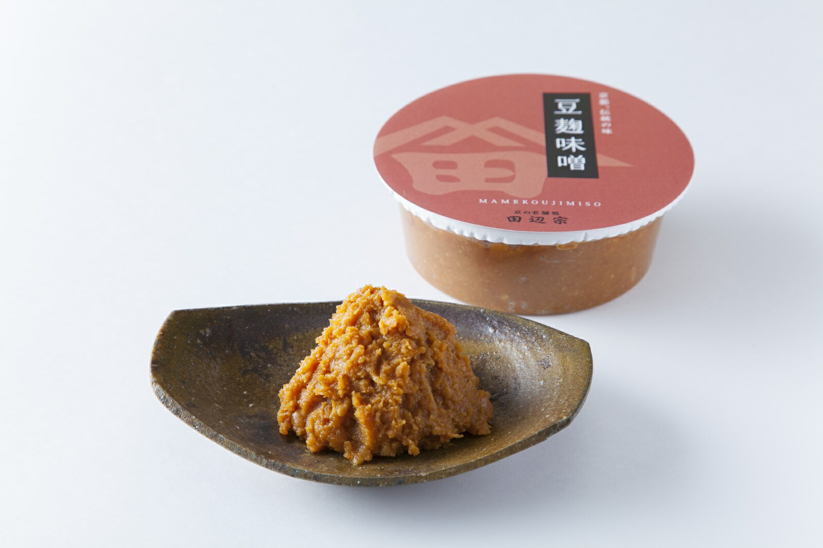 ・名称：豆麹味噌　300gカップ入り ・内容量：300g ・賞味期限：150日(製造日より) ・保存方法：冷暗所　直射日光,高温多湿の所での保存は避けて下さい ・原材料：大豆（遺伝子組み換えでない）　米　食塩　酒精 ・販売者：株式会社田辺宗 　　　　　京都市上京区出町枡形上がる青龍町218