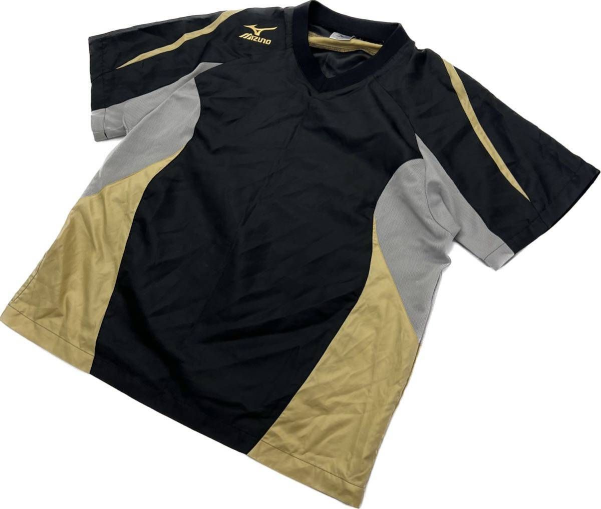 MIZUNO ☆ 春夏 ウィンドジャケット 半袖 ナイロンシャツ Tシャツ グレー ゴールド ブラック M サッカー フットサル 定番 ミズノ■CD259 ブランド：MIZUNO サイズ表記・実寸（平置き計測）表記：M 実寸：着丈66cm身幅57cm肩幅53cm袖丈17cm ※必ず実寸をご確認の上、ご購入ください。※多少の誤差はご了承ください。 コンディション状態：背中に擦れがありますが問題なくご着用頂けます。 状態ランク：10中 7（中古品と言うことにご理解いただける方のみご購入をお願い致します。）