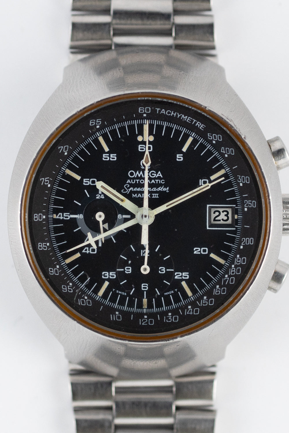 COMMENT ケースフォルムがユニークなスピードマスターマークIII。フライトマスターなどにも使用された通称「ボルケーノ（火山）」と呼ばれるものです。ケースメーカーはスーパーコンプレッサーなど防水性に優れたケースを開発していたEPSA（Ervin Piquerez SA）製、裏蓋の内側にはダイビングベルをデフォルメした刻印が見られます。ダイヤルはブラックマット。9時位置のインダイヤルは永久秒針の下に24時間表記の時刻を示すディスクを搭載しています。クロノグラフ秒針はスピードマスターと同様の形状です。羽の生えた針はクロノグラフの1時間積算計です。6時位置のインダイヤルは12時間積算計です。ブレスレットはRef.1162とエンドリンク172です。 ケースはオリジナルのプロポーションをよく残したグッドコンディションです。ダイヤルは当時の色味をよく残したミントコンディションです。傷や汚れなどの気になるようなダメージはありません。タキメーターがプリントされたインナーベゼルは濃いブラックカラーを残しています。針やレターのプリントに劣化は見られません。アプライドのインデックスはキラキラと上面を輝かせており、やれた印象を一切抱かない素晴らしいコンディションです。夜光塗料は素晴らしいベージュカラーを見せています。弊社にて分解掃除済みです。 厚み16.0mmの迫力溢れるケースデザインが際立っています。腕に装着した際の重厚な感触と、未来的なデザインはまさに1970年代のヴィンテージウォッチを楽しむ真髄と言えるでしょう。 BRAND 今でこそ「Speedmasterイコール宇宙」という図式がすぐに浮かび上がりますが、当時は宇宙とは全く関係のない、純粋なモータースポーツ用の時計として誕生。また、スピードマスターは、ダイヤルではなく外周ベゼルにタキメーターを表示した世界で初めての時計と言われています。1959年、スピードマスターはマイナーチェンジをします。ベゼルがアルミニウムの黒色ベースとなり、針の形状がアロー針からアルファ針に変更されたことで、より視認性が高まっています。NASAは宇宙での過酷な環境にも耐えうる丈夫なクロノグラフを探しており、名だたる強豪に勝ったスピードマスターを公式時計として採用。その後1969年人類初の月面着陸の際、スピードマスターを着用していたことは有名な話。 ?BRAND OMEGA MODEL SPEEDMASTER MARKIII REFERENCE 176002（176.002） YEAR 1970's MATERIAL Stainless Steel WINDING Automatic CALIBER 1040 SERIAL 31++++++ CASE?DIAMETER? 52.0mm × 41.0mm CASE THICKNESS 16.0mm BETEWEEN LUGS 22.0mm SERVICE Yes GUARANTEE 1 Year STRAP OMEGA?Genuine Bracelet BOX and PAPERS No COMMENTThe unique case design of the Speedmaster Mark III, often referred to as "Volcano," utilized by other models like the Flightmaster. The case, developed by EPSA (Ervin Piquerez SA), known for creating waterproof cases like the Super Compressor, features a distinctive engraving on the inside of the case back, resembling a deformed diving bell. The black matte dial includes a 24-hour disc beneath the perpetual seconds sub-dial at 9 o'clock. The chronograph seconds hand shares the same shape as the Speedmaster, and the winged hand serves as the 1-hour accumulator for the chronograph. The sub-dial at 6 o'clock functions as a 12-hour accumulator. The bracelet is a Ref.1162 with Endlink 172.The case remains in good condition, preserving the original proportions. The dial is in mint condition, maintaining the coloration of that era with no noticeable damage such as scratches or stains. The inner bezel, printed with a tachymeter, retains a deep black color. There is no deterioration observed in the hands or letter prints. The applied indices shimmer on the surface, presenting an excellent condition without any signs of wear. The luminescent paint displays a beautiful beige color. The watch has been disassembled and cleaned by our company.The imposing case design, measuring 16.0mm in thickness, stands out, providing a powerful feel when worn on the wrist. The combination of a substantial touch and futuristic design truly encapsulates the essence of enjoying vintage watches from the 1970s.BRANDWhile today the equation "Speedmaster equals space" is readily apparent, during its inception, the Speedmaster had no connection to space but was purely designed as a chronograph for motorsports. Additionally, the Speedmaster is recognized as the first watch in the world to display a tachymeter on the outer bezel instead of the dial. In 1959, the Speedmaster underwent a minor change with the bezel transitioning to a black aluminum base and the hands changing from arrow hands to alpha hands, enhancing visibility. NASA sought a robust chronograph capable of withstanding the harsh conditions of space and officially adopted the Speedmaster after it triumphed over formidable competitors. The iconic story of the Speedmaster being worn during the first moon landing in 1969 is well-known.