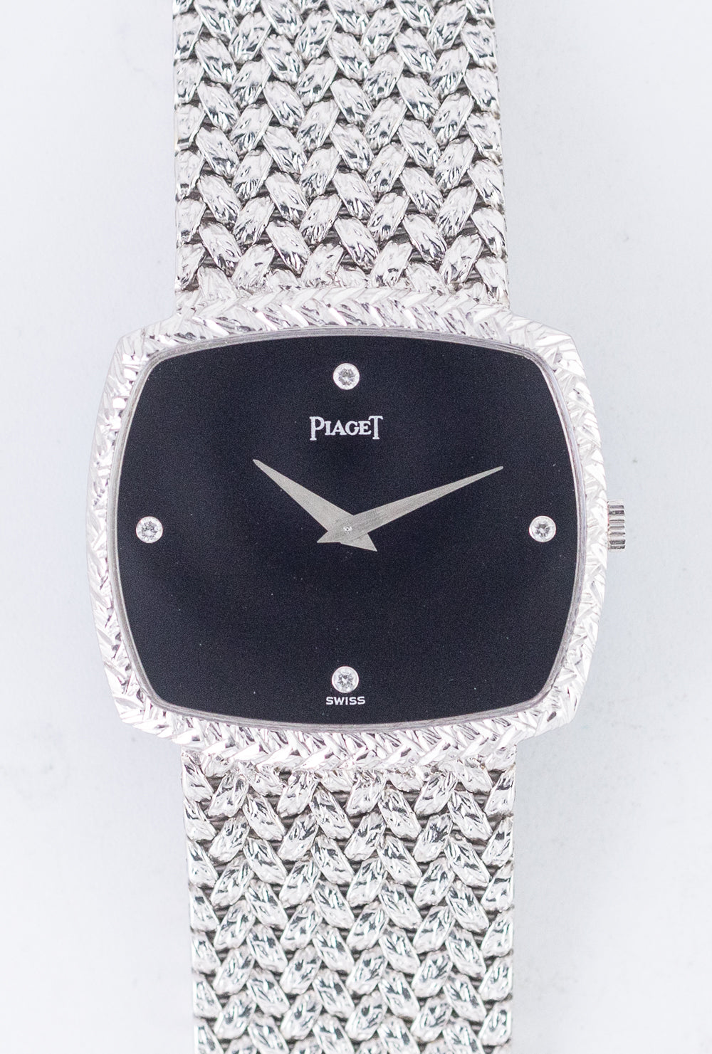 COMMENT 宝飾時計ブランドでありながら、自社一貫製造体制を持つマニュファクチュールとして、唯一無二の地位を確立しているピアジェ。本モデルは、18金無垢ホワイトゴールド製のスクエアケースに、同素材のインテグラルブレスレットを組み合わせています。ケースおよびブレスレット上面には、ピアジェらしい繊細な金細工が施され、装飾性と洗練が見事に融合しています。ダイヤルはオニキスで構成され、インデックスの代わりにダイヤモンドをセット。盤上にはメーカーロゴと「SWISS」のみが記され、無駄を削ぎ落としたミニマルな美が際立ちます。クォーツショックの時代にあっても、こうした手巻き2針のドレスウォッチは、機械式時計の再評価の流れを象徴する存在でした。 本個体は、ほとんど使用されていないことが明らかな素晴らしいコンディションを保っています。ケースバックには当時のシールが残っており、ホールマークや各エッジも鮮明。ダイヤルはスーパーミントで、天然オニキスにしばしば見られるクラックも確認されません。弊社にて分解掃除済みのため、コレクションとしてはもちろん、実使用にも安心してご活用いただけます。 クラシカルでありながらマスキュリンな印象も兼ね備える、現代にも通じる優美なドレスウォッチ。ピアジェが追求した金細工の技と、オニキスという素材が持つ静謐な存在感の組み合わせは、まさに唯一無二です。ピアジェほどケース造形にこだわり抜いたメーカーは稀であり、その哲学と美意識が詰まった本作は、ジュエラーウォッチの真髄を体現する逸品です。 BRAND 1874年創業の宝飾時計ブランド。世界に僅かしかない完全一貫生産を行うマニファクチュールであるという点において、通常の宝飾時計ブランドとの決定的な違いがある。カルティエやオーディマ・ピゲ等にムーブメントを供給するなど、ムーブメントメーカーとしての実績もある。そして技術と共に、デザイン性においても高い評価を受け、時計界のジュエラーと称えられている由緒あるメーカーとして確固たる地位を確立している。 ? BRAND PIAGET MODEL - REFERENCE 91547 YEAR 1980's MATERIAL 18K White Gold WINDING Manual CALIBER 9P2 SERIAL 349+++ CASE DIAMETER 28.9mm × 31.2mm CASE THICKNESS 5.3mm BETWEEN LUGS - SERVICE Yes GUARANTEE 1 Year STRAP PIAGET Genuine 18K Bracelet BOX and PAPERS Box ? COMMENT While best known as a jewelry house, Piaget has also earned its place as a true manufacture, producing its own timepieces entirely in-house?a rarity even among luxury watch brands. This particular model showcases that mastery through an 18K solid white gold square case seamlessly integrated with a matching white gold bracelet. Both the case and bracelet feature Piaget’s signature artisanal goldwork, blending ornate detailing with refined elegance. The dial is made of pure black onyx, accented only by diamond-set hour markers. Devoid of numerals or excess text, the dial bears only the Piaget signature and “SWISS,” creating a minimalistic yet luxurious aesthetic. Despite being released during the height of the Quartz Crisis, this hand-wound two-hand dress watch stood as a quiet symbol of the mechanical watch's enduring value and prestige. This example remains in exceptional, near-unused condition. The original caseback sticker is still intact, with crisp hallmarks and sharp edges throughout. The dial is in superb mint condition with no visible cracks?something often found in natural onyx. Fully serviced by our watchmaker, it’s ready for both display and regular wear. Elegant and classical, yet subtly masculine, this timepiece feels strikingly modern. The combination of intricate goldsmithing and the quiet depth of onyx makes it truly one-of-a-kind. Few brands have dedicated themselves to case design the way Piaget has, and this piece embodies the brand’s philosophy of artistry and restraint. A perfect representation of the jeweler-watchmaker ideal. BRAND Founded in 1874, Piaget is a storied maison known for blending haute horlogerie with high jewelry. What sets Piaget apart is its status as one of the very few maisons to operate as a true manufacture?designing, developing, and producing every component in-house. Beyond crafting its own movements (some of which were supplied to brands like Cartier and Audemars Piguet), Piaget has built a legacy of ultra-thin calibers and daring design. Today, it is celebrated not just for its technical accomplishments, but for its position at the intersection of watchmaking and jewelry artistry. ? ?