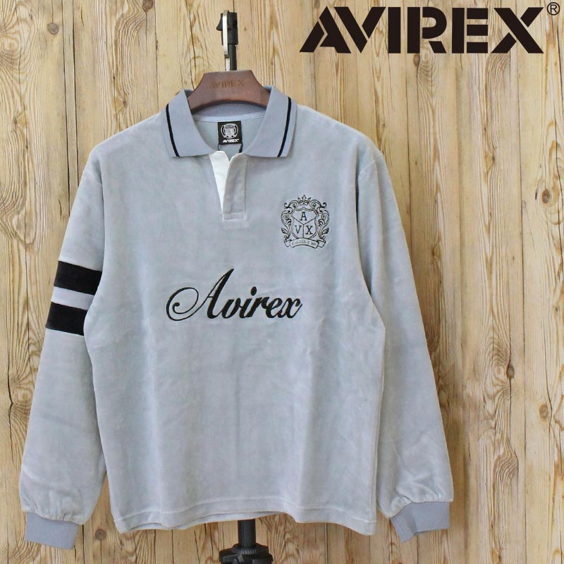 VELOUR SKIPPER POLO/ベロアスキッパーポロ/AVIREX/アビレックス 滑らかな光沢感が特徴のベロア素材を使用した、スキッパー風デザインの襟付きトップス。 程よく開いた前立てが抜け感を演出し、カジュアルでありながらも上品な印象に仕上げています。 襟元には布帛ライクな切り替えを取り入れ、 ベロア素材とのコントラストがデザインのアクセントに。 袖にはラインデザインを施し、クラシックなスポーツウェアやバーシティアイテムを思わせる表情を加えています。 フロントにはロゴグラフィックを配置し、 主張しすぎないバランスで表現をしています。 【AVIREX/アヴィレックス】 1975年にアメリカ空軍のコントラクターとして創業し、フライトジャケットを供給した事でその認知度を飛躍的に高めた。 ミリタリーに起源を持つアヴィレックスは、機能的なデザインが醸し出す特有の美しさに支えられている。 その個性的な表情は、映画「インディー・ジョーンズ」「トップガン」「メンフィスベル」などのスクリーンでも活躍し、喝采を浴びた。 その無駄の無いデザイン、ノスタルジックな味わいは今なお世界中の多くの人々から支持され続けている。 カラー 1-ブラック 2-グレー 素材：綿65% ポリエステル30% ポリウレタン5% ※製造工程の過程による、小さなほつれ、微小な縫製のずれなどの 返品対応は致しかねます。ご了承ください。