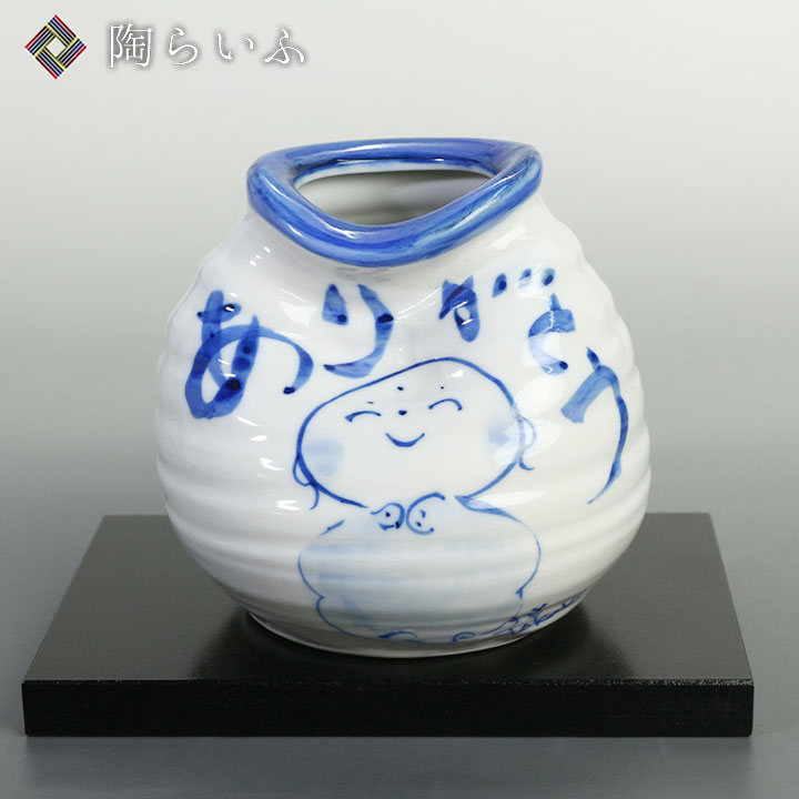 【九谷焼】4号一輪生(花台付) ありがとう/東孝子【九谷焼】4号一輪生(花台付) ありがとう/東孝子 商品説明 ＜東孝子の手作り、手描きの商品です。＞ 遊び心と創造力をプラスした東 孝子（ひがし たかこ）の作品。 「ありがとう」の感謝の言葉が、そっと心を和ましてくれます。 古き良き九谷焼の魅力を生かした一品です。 商品詳細情報 商品サイズ 花瓶：径13×高12cm花台：奥8.8×横幅15.5×高さ1.2cm 箱の種類 化粧箱 作家 東孝子 東 孝子 Higashi Takako 自由な遊び心と優しさと。笑顔を届ける創作陶器 九谷焼の染絵付を学び、置物から日常の食器まで幅広く手がける東孝子。 目指すのは、手に取った人が思わず笑顔になり、心が豊かになるような器づくり。丁寧な手作りの器をベースに、時には器へ直接メッセージを添えるなど、自由で遊び心溢れる創作が大きな魅力です。 暮らしにそっと寄り添い、使うたびに明るい気持ちを運んでくれる、ぬくもりあふれた九谷焼の魅力をお楽しみいただけます。 九谷焼 世界に誇るジャパンクタニ伝統が生み出した五彩の美ジャパン・クタニとして、世界中から評価され、その名を馳せる九谷焼。約360年の歴史と伝統の技が、現代にも継承され、あまたの人々に長く愛され続けています。豪放華麗な色絵装飾を中心とした、独特な風格を誇る石川県金沢の伝統工芸。鮮やかに日常生活を彩ります。九谷焼の作品の魅力は、五彩(赤・緑・黄・紫・紺青)を基調とした、その独自の色彩が重なりあって生まれる重厚感にあります。北国ならではの力強い素地に、優美な色絵装飾を施し、作品を作り上げられています。手にとった時に感じる、和絵具のなめらかな質感もきっと楽しんでいただけることでしょう。独自な個性を放ちながら、生活に深く息づいていく伝統工芸品「九谷焼」。どうぞ末永くご愛用ください。 用途や贈る相手に合わせて、8種類のギフト包装紙からご選択いただけます。 熨斗のご要望があれば、お申し付けください。用途に合わせた熨斗をご用意いたします。 贈り物と共に、相手へメッセージを伝えるお手伝いをいたします。無記入のメッセージカードの同梱も可能です。 ご希望の方には、商品の大きさに合わせて、各種紙袋をご用意しております。 ＜陶らいふ＞ギフト 行事一覧（こちらの商品は以下のような 贈り物 用途に適しています） 【おすすめ】伝統工芸品 石川県 金沢 和食器 九谷焼の贈答で"想い"を届ける 結婚祝い / 内祝い / 結婚式（引き出物） / 父の日 / 母の日 / 敬老の日 / 出産祝い / 成人祝い / 新築祝い / 還暦祝い / 快気祝い / 入学祝い / 就職祝い / 退職祝い / 引越し祝い / 独立・開業祝い / 誕生日祝い / 還暦祝い / 古希祝い / 喜寿祝い / 傘寿祝い / 米寿祝い / 金婚式 銀婚式 祝い / お中元 / お歳暮 /など その他「陶器 ギフト」として、 お土産 / 記念品 / お祝い返し / 粗品 /などとしても 人気 があります。