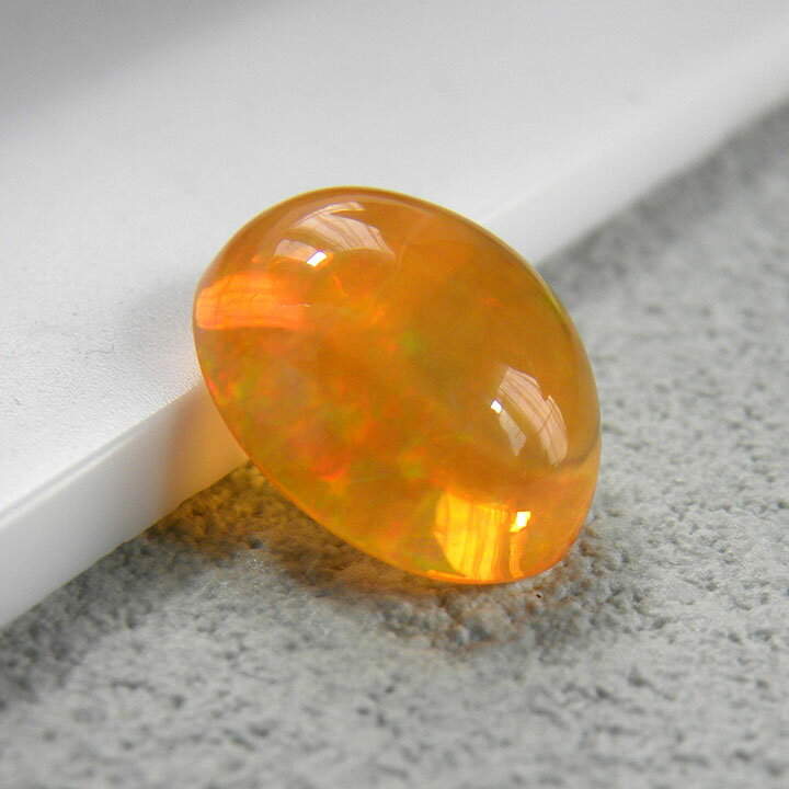 大粒でふっくらと厚みがあり、オレンジ色の中にプレイオブカラー（遊色効果）が美しく湧き上がるファイアオパールのルースストーン。角度を変えて湧き上がる色彩や、1つとして同じもののない天然の美しさをお楽しみいただけます。ジュエリー作りに最適なピー...