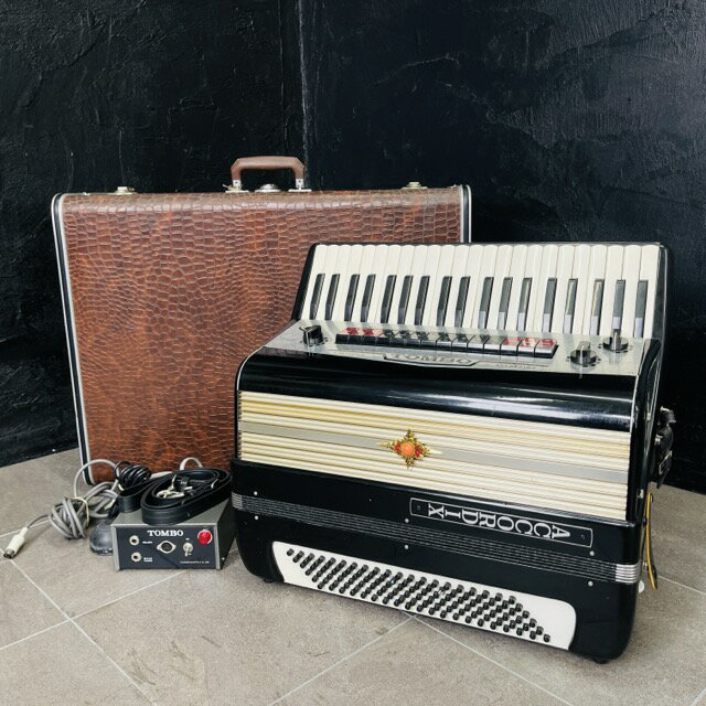 電子アコーディオン 【中古】TOMBO トンボ ACCORDIX A-120 パワーサプライ ケース付き 現状品 楽器 鍵盤 / 515563 商品詳細 型番: A-120 製造番号: EEXD-005 サイズ(幅/奥行き/高さ): 約 51/21/44.5 cm ※箱の幅68.5奥行き27高さ51 ※素人寸法です。若干の誤差はご了承下さい。 電源ユニット、フットスイッチ、ベルトが付属しています。 商品は写真にあるもので全てです。 必ず写真で確認お願い致します。他にもたくさん出品しています。 状態 状態ランク D　キズや汚れがある 状態ランク表 SSS　新品未開封 SS　未使用品 S　展示品 A　使用感が全くなく綺麗 B　目立ったキズや汚れ無し C　少しキズ、汚れがある D　キズや汚れがある E　目立ったキズ、汚れがある F　目立ったキズ、汚れが多くある G　破損個所がある H　破損個所が多くある 状態チェック担当者のコメント全体的にキズ汚れが多くダメージがあります。 ベースボタン部分が凹んでいて戻りません。本体やベルトに取り切れない埃が残っています。側面に凹みがあります。ケースが全体的に拭いても汚れています。ケース、本体共に金具にサビがあります。 動作 動作ランク B　一部分のみ未チェック 動作ランク表 S　新品未開封 未使用 A　動作問題なし B　一部分のみ未チェック C　多少難有り D　通電のみ確認 E　難有り F　未チェック G　ジャンク品 動作チェック担当者のコメント 現状でのお渡しになります。予めご了承の上ご入札をお願いいたします。 音が出ることのみ確認しています。細かな確認はしておりません。 支払詳細 ページ下部にてご確認ください。 発送詳細 佐川急便160サイズにて埼玉県より発送いたします。送料はこちらを御覧下さい。送料無料の商品はご参考までにご覧下さい。※離島、沖縄は発送しておりません。予めご了承下さい。 注意事項 ※タイトルの末尾は管理番号となります。※ジャンク品の商品は、故障や破損、欠品、動作未確認、 正常な動作のお約束ができない等、様々な理由にてジャンク品として販売をさせて頂いております。その為、商品の返品・返金・交換等の 対応は出来ません。修理、パーツ取りなどを想定しお買い求め下さい。 ※保証について動作保証と記載のある商品については、商品に不具合が生じた場合、商品到着後8日以内は返品、返金をお受けいたします。取付や工事が必要なものに関しましては、それに必要な費用は当方では負担致しません。 取付費、工事費は保証対象外となります。当方で販売いたしました商品が明確な原因で重大な事故へと発展いたしました場合にも、商品代金の2倍以上の責任は負いかねます。商品を利用される際には、必ず状態をご確認ください。 ※評価について恐れ入りますが当方から評価はしておりません。評価が必要な場合、受取連絡の際に取引ナビでご連絡下さい。よろしくお願い致します。 誠に勝手ながら各週日曜日が定休日となります。そのためご連絡、発送、手渡し対応等行っておりません。予めご了承の上ご落札をお願い致します。 同梱ご希望の場合は必ずお支払い前にご連絡をお願い致します。※ 新品及び未使用品は商品到着後8日間の動作を保証いたします。
